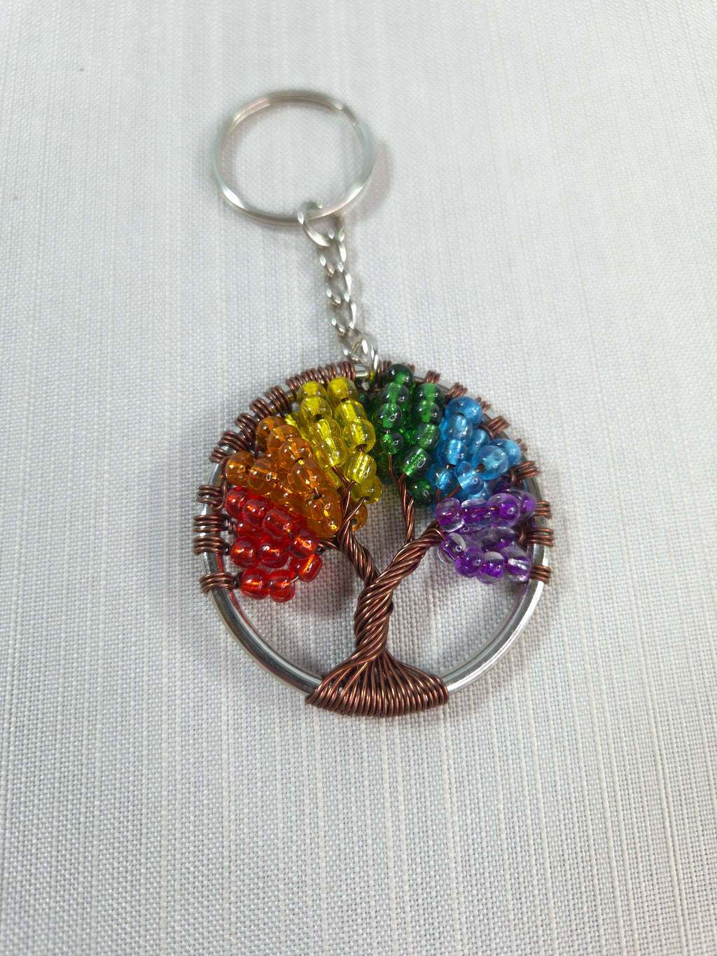 Keychain with rainbow-colored beaded tree design on a white background