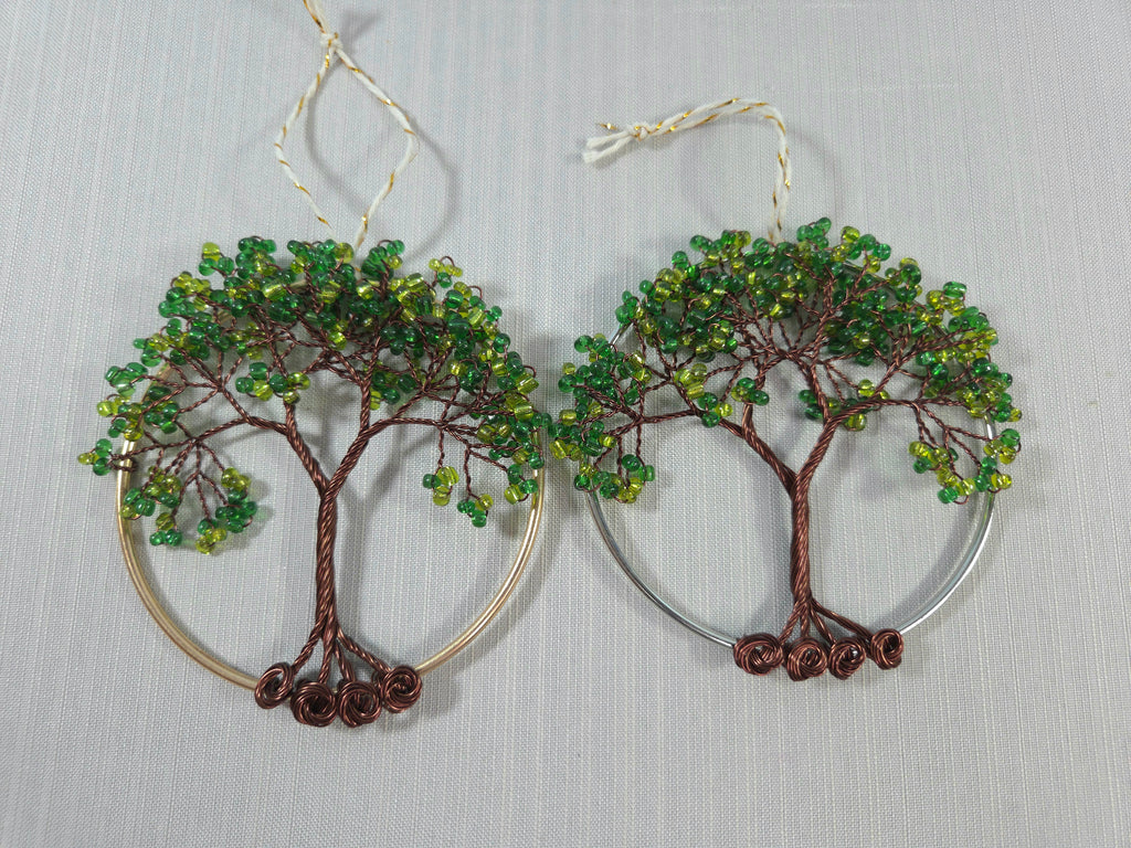 Tree-shaped earrings with green beads on a gray background