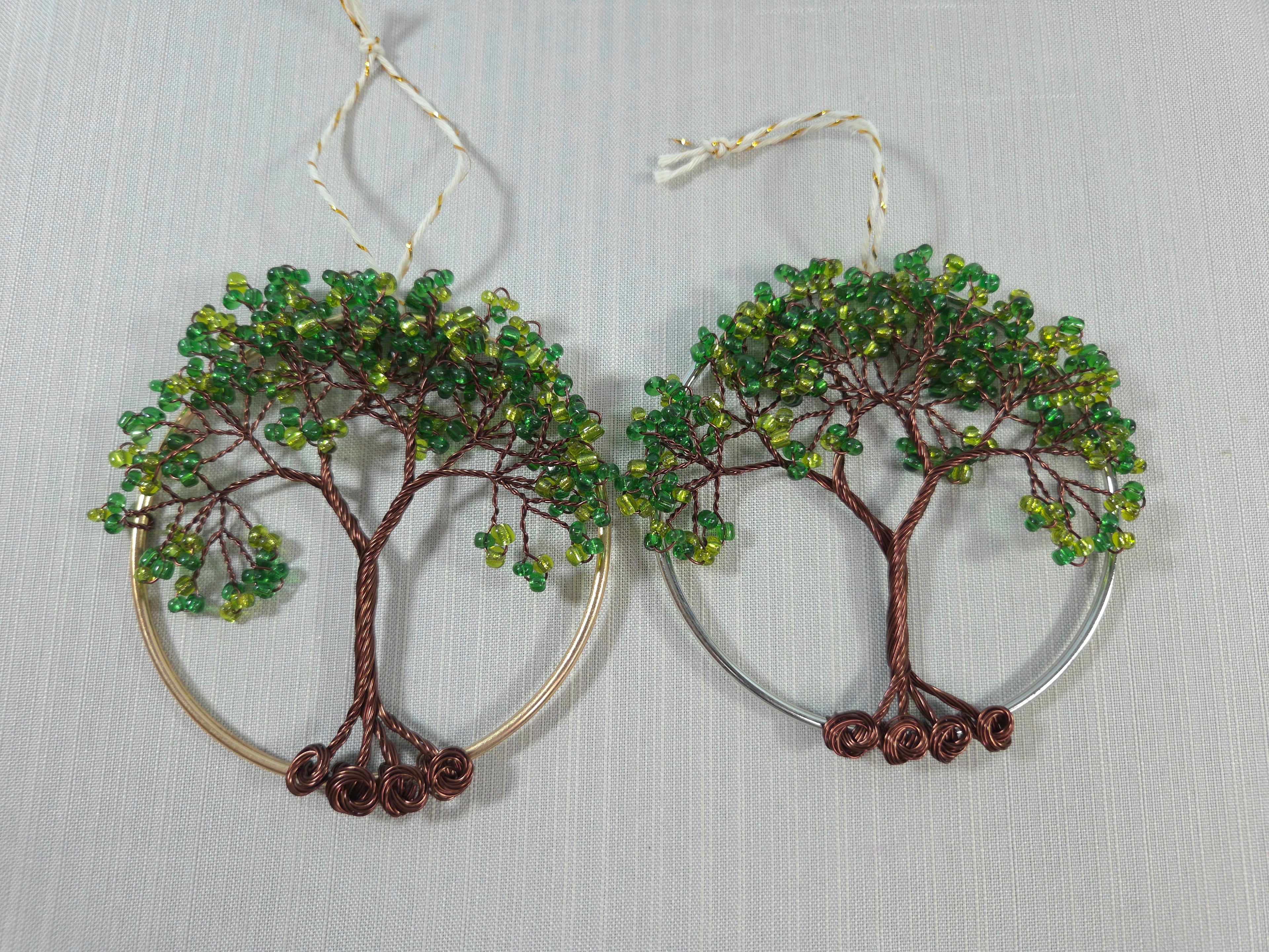 Tree-shaped earrings with green beads on a gray background