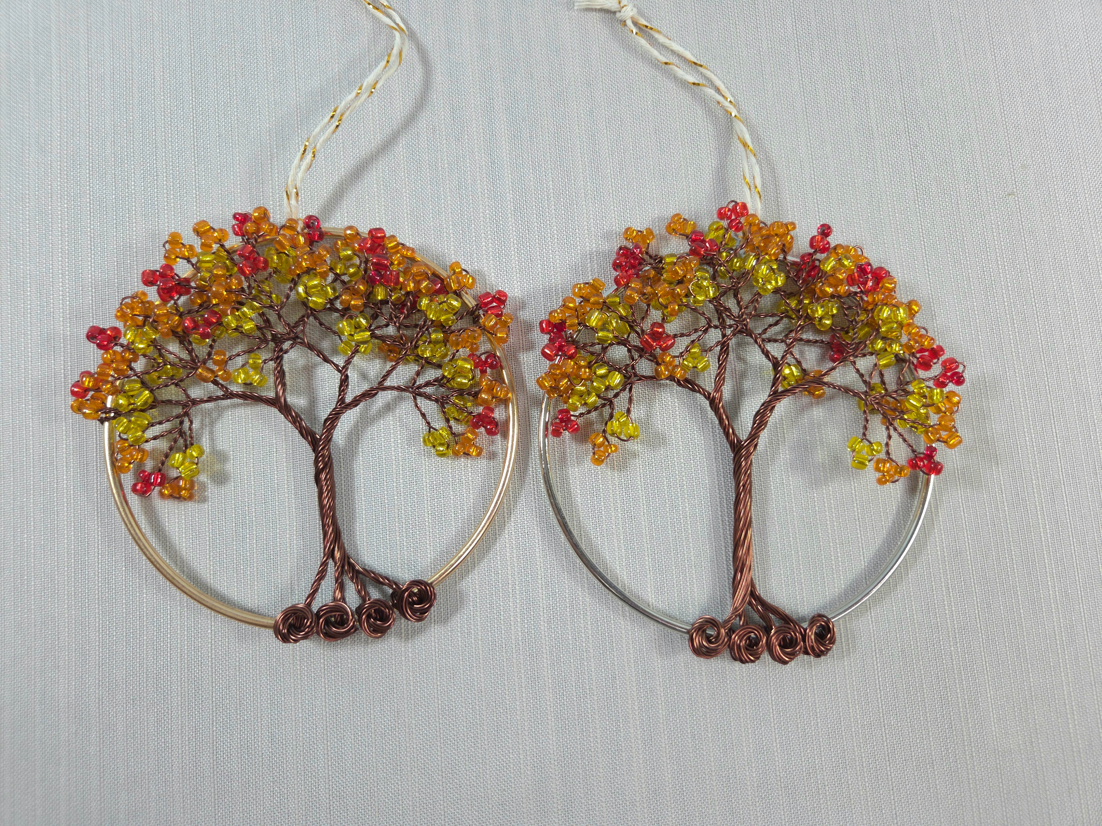 Tree-shaped earrings with colorful beads on a light gray background