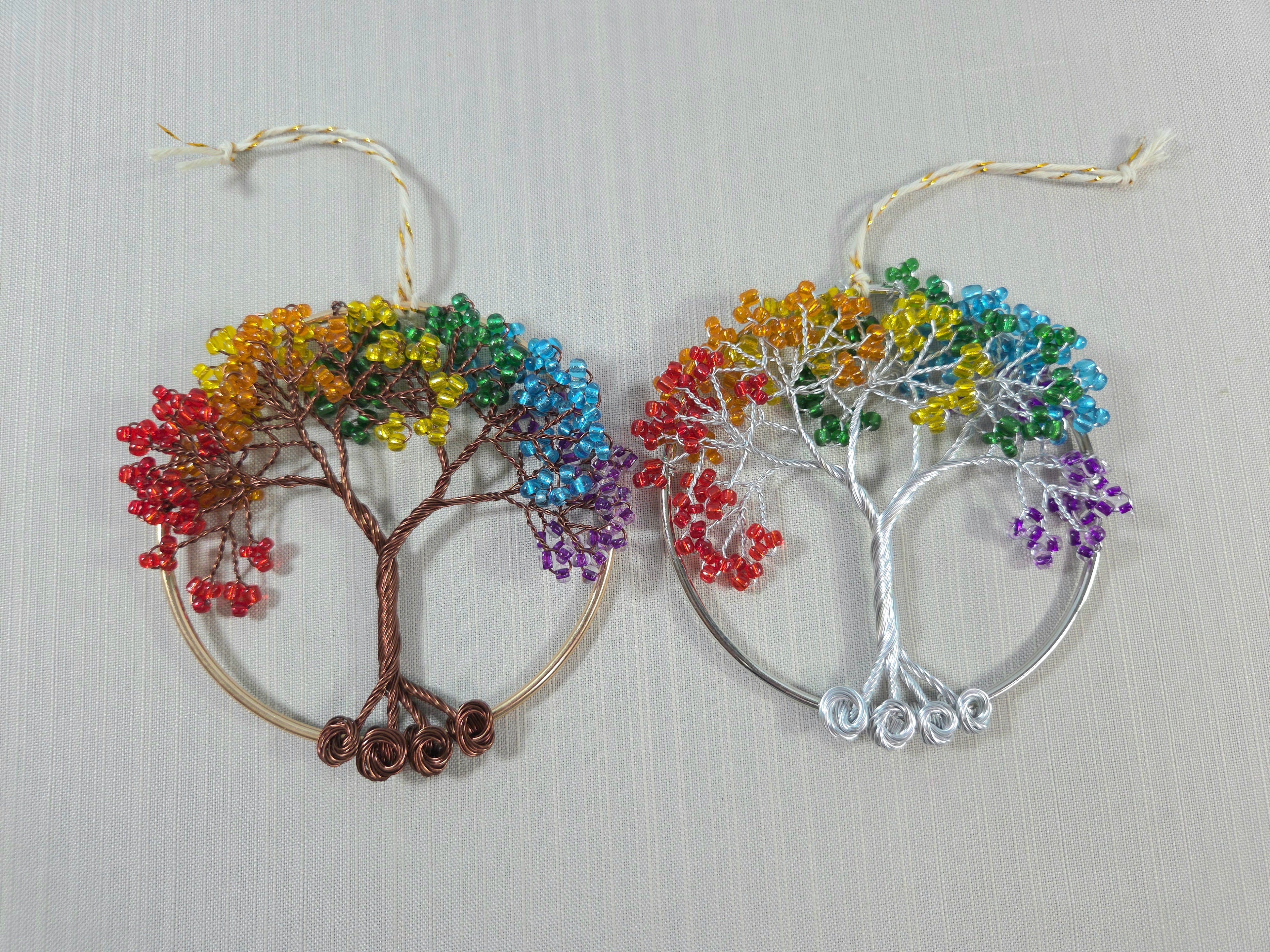 Two rainbow-colored tree-shaped decorations on a light gray background