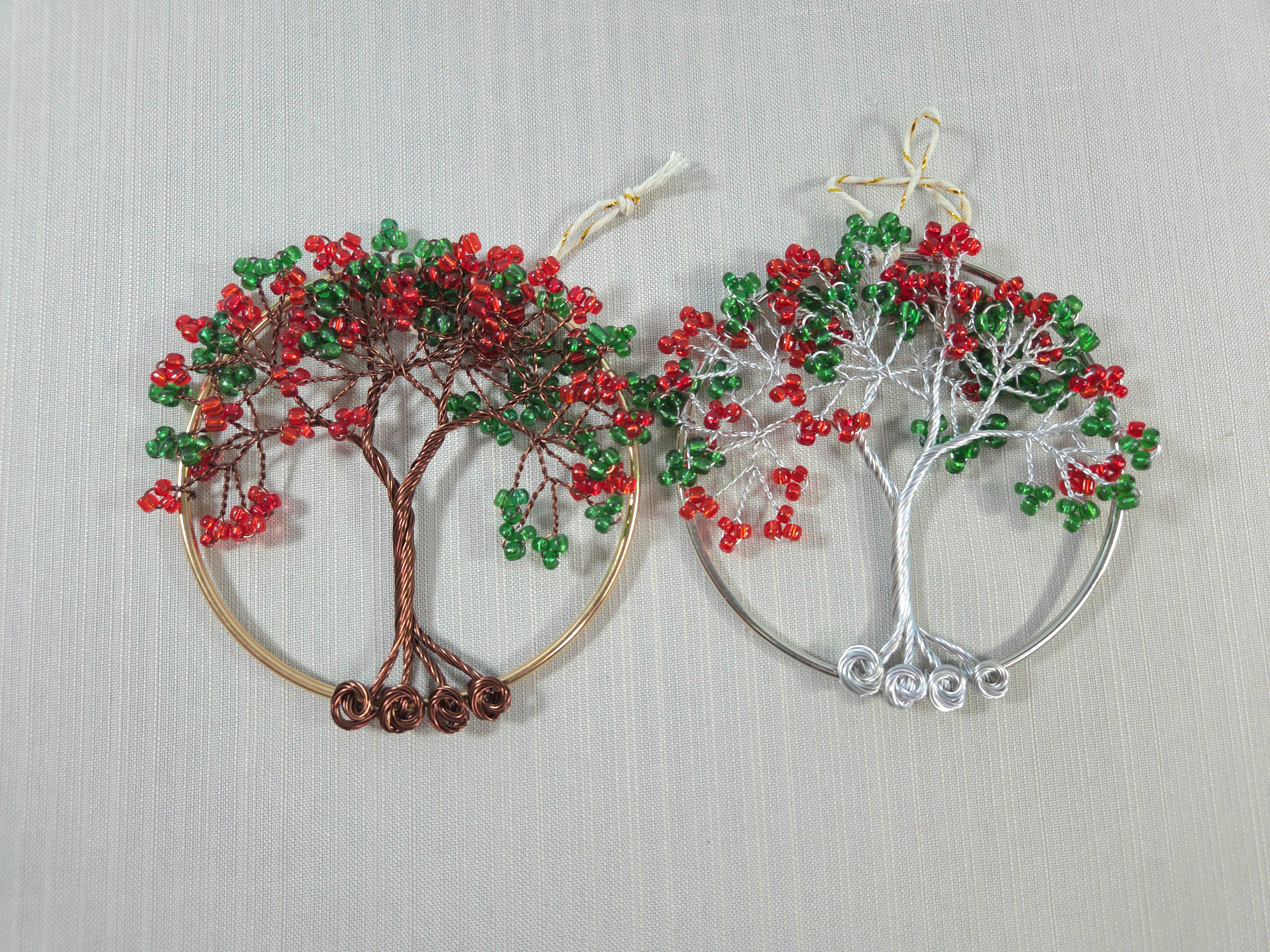 Tree-shaped earrings with red and green beads on a light gray background
