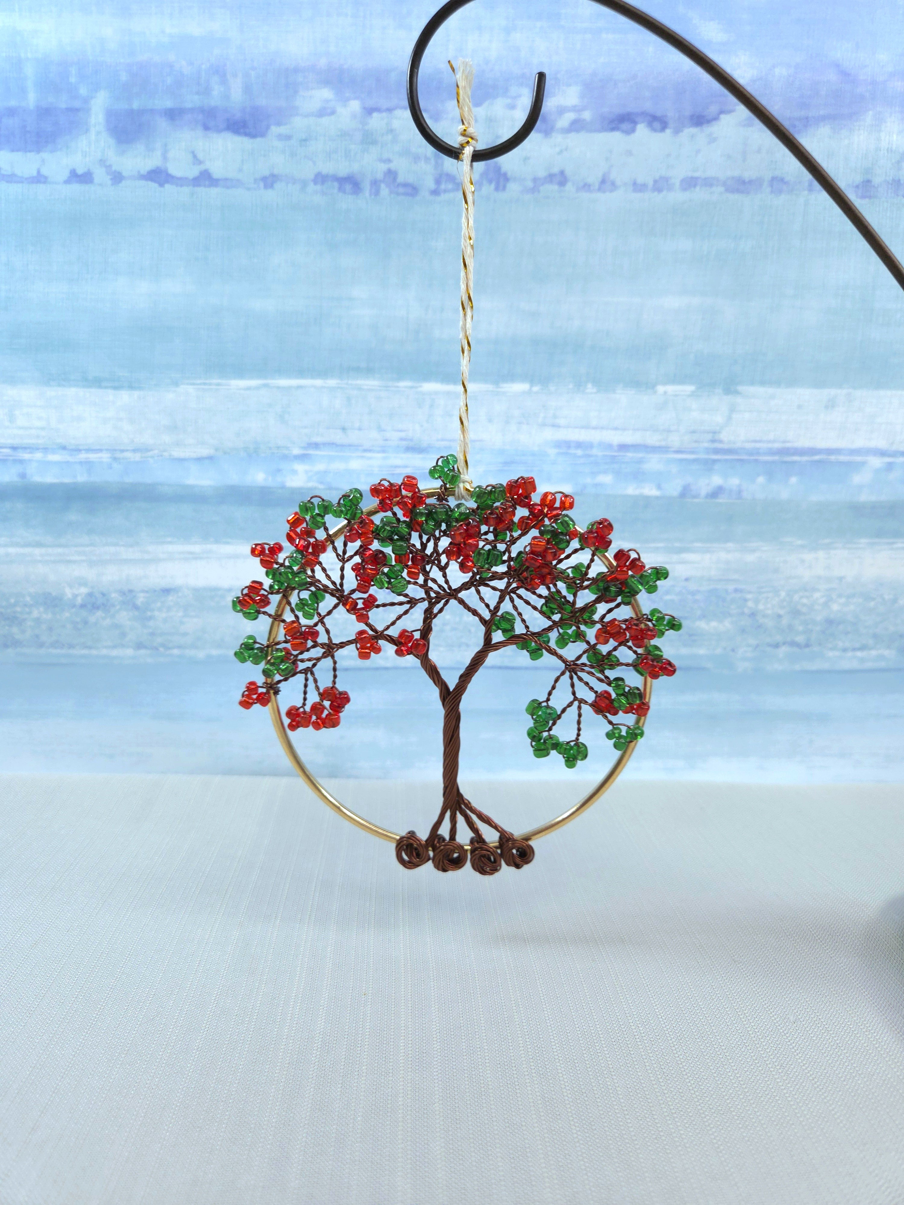 Decorative tree ornament with red berries and green leaves on a blue and white background
