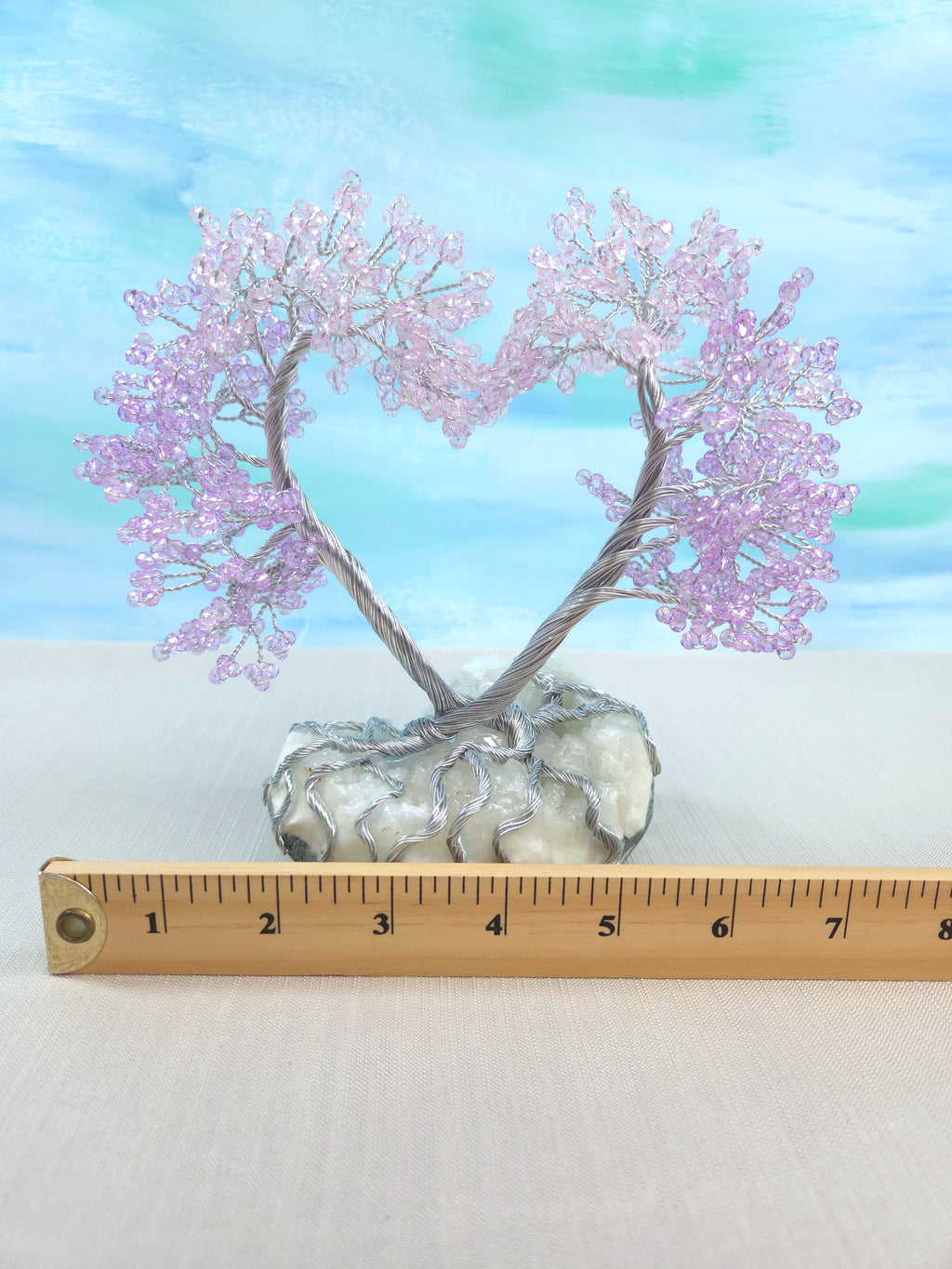 Decorative tree with pink blossoms on a white base, measured against a ruler.