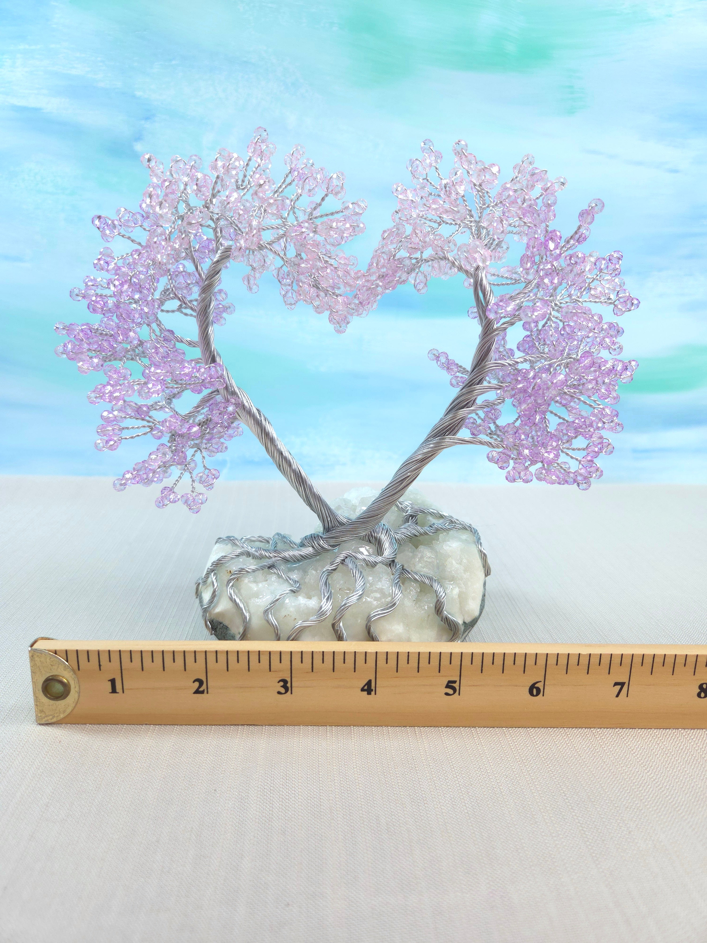Decorative tree with pink blossoms on a white base, measured against a ruler.