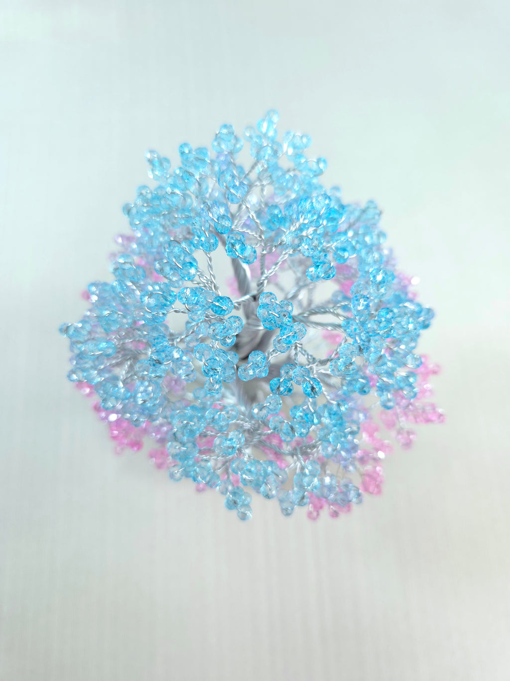 Decorative wreath with blue and pink beads on a white background