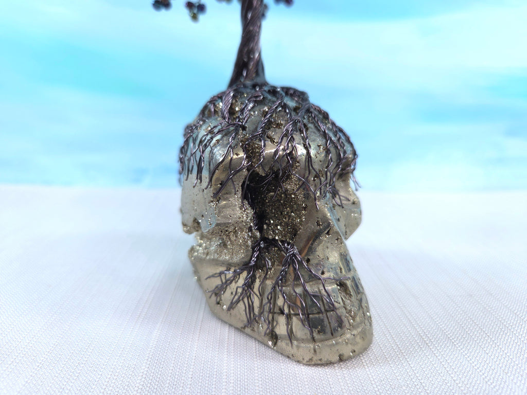 Decorative skull with tree-like branches on a white surface with a blue gradient background