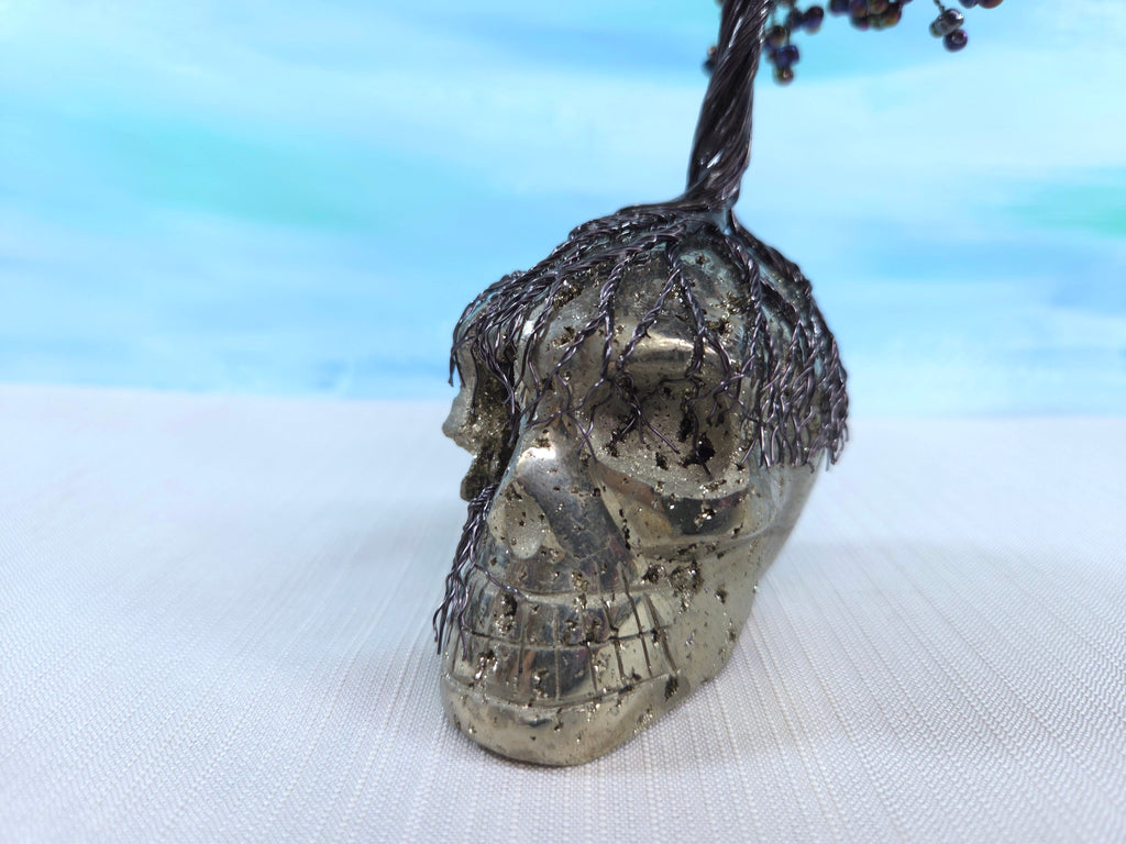 Decorative skull with wire detailing on a white surface with a blurred blue background