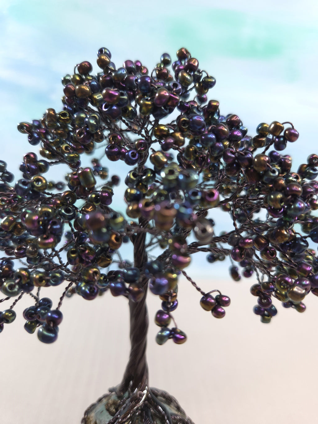 Tree sculpture with beaded branches against a blurred background