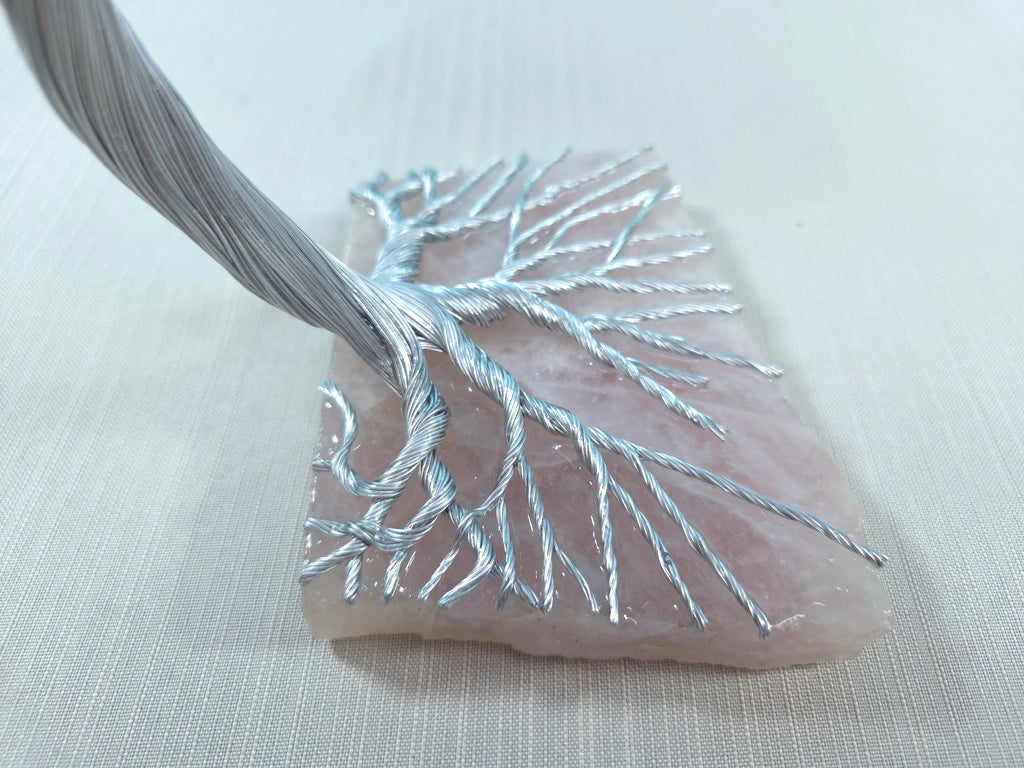 Decorative leaf with silver thread on a light fabric background