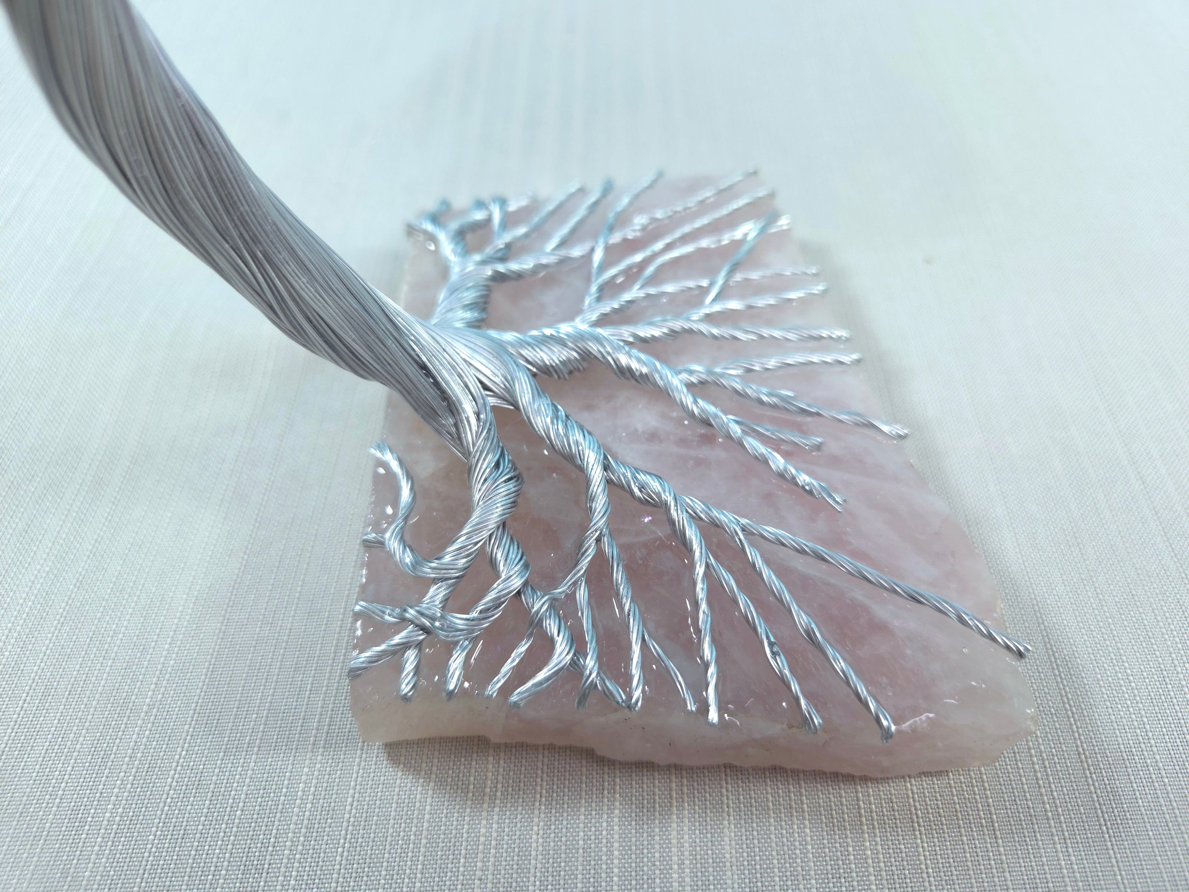 Decorative leaf with silver thread on a light fabric background