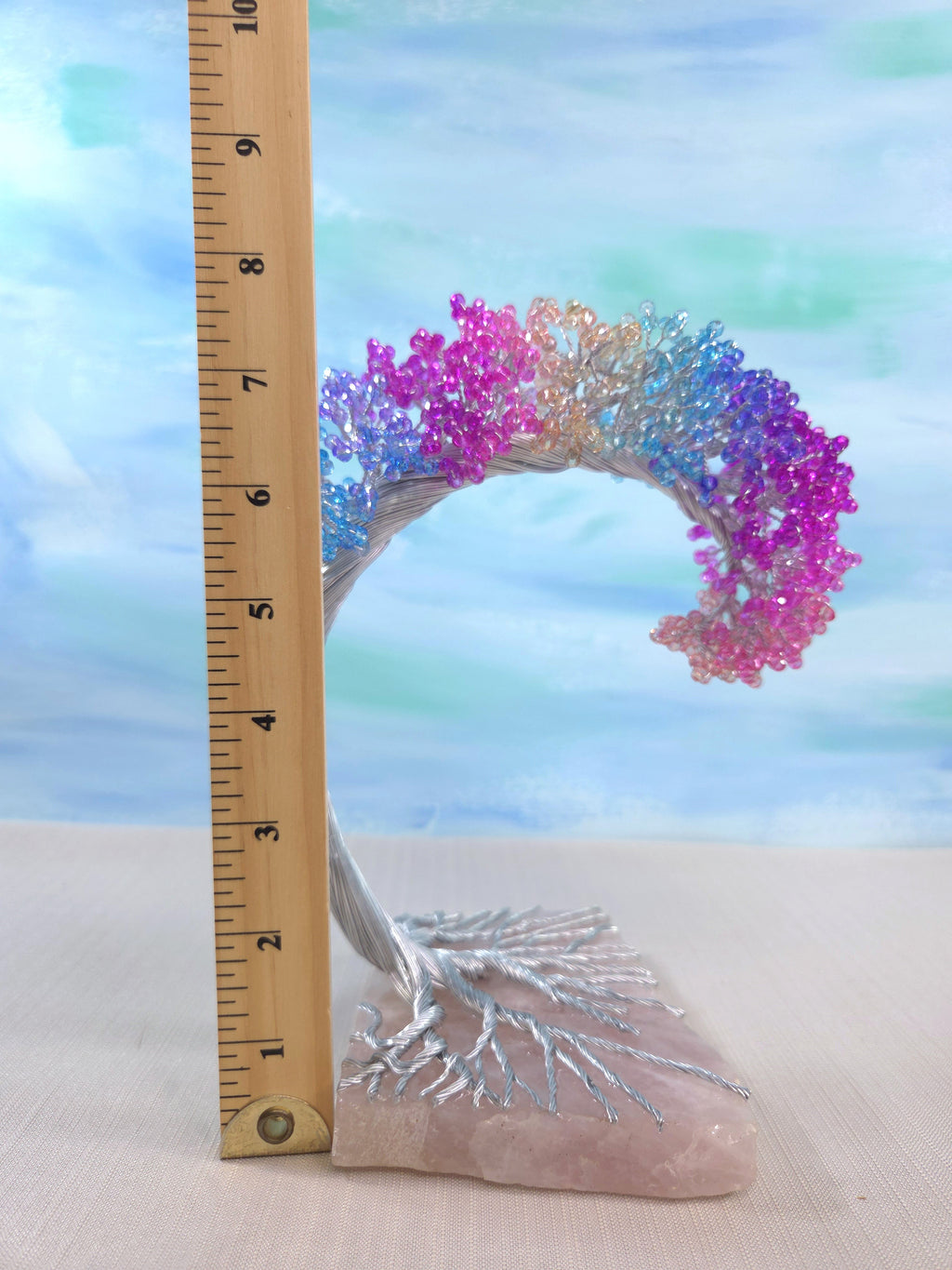 Colorful coral-like structure on a rock with a ruler for scale against a blurred natural background