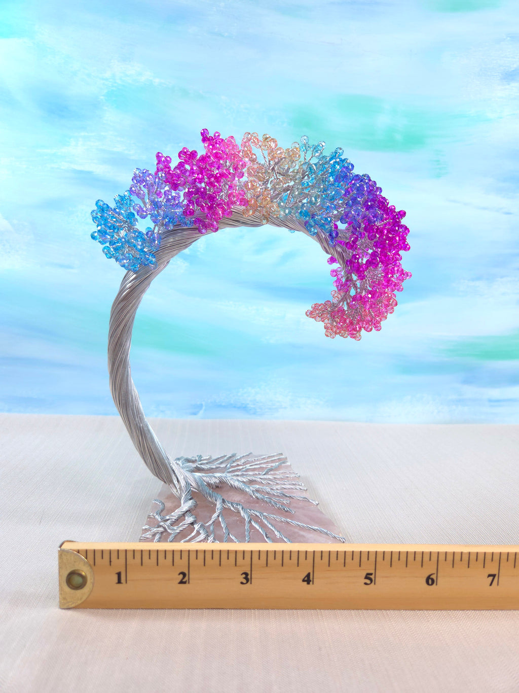 Colorful butterfly wreath with a ruler for scale against a pastel sky background