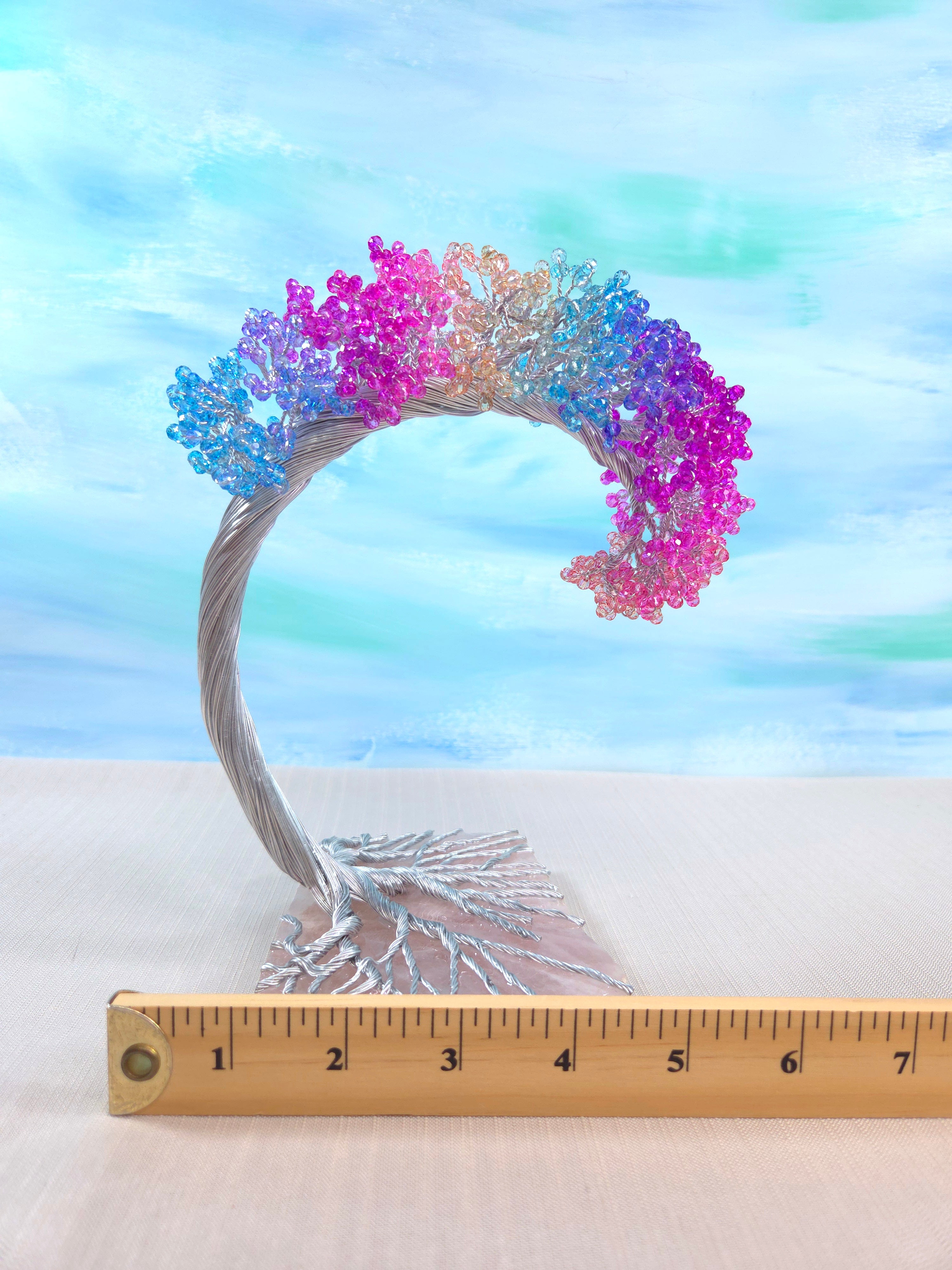 Colorful butterfly wreath with a ruler for scale against a pastel sky background