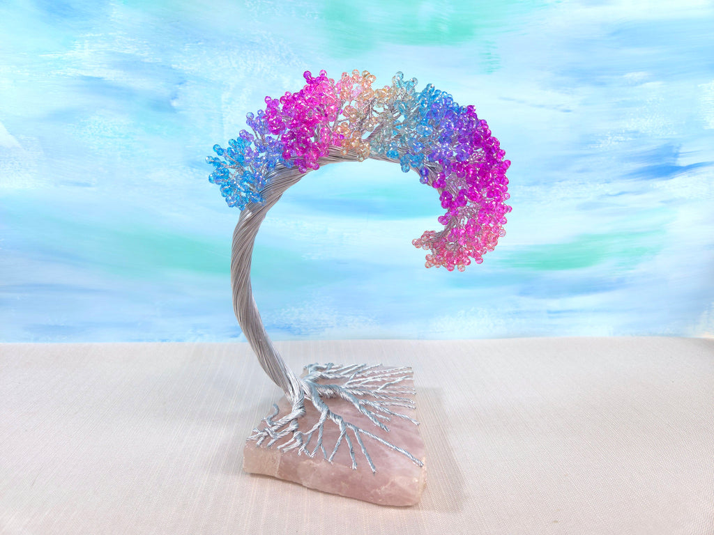 Decorative arch with colorful flowers on a stone base against a blurred natural background