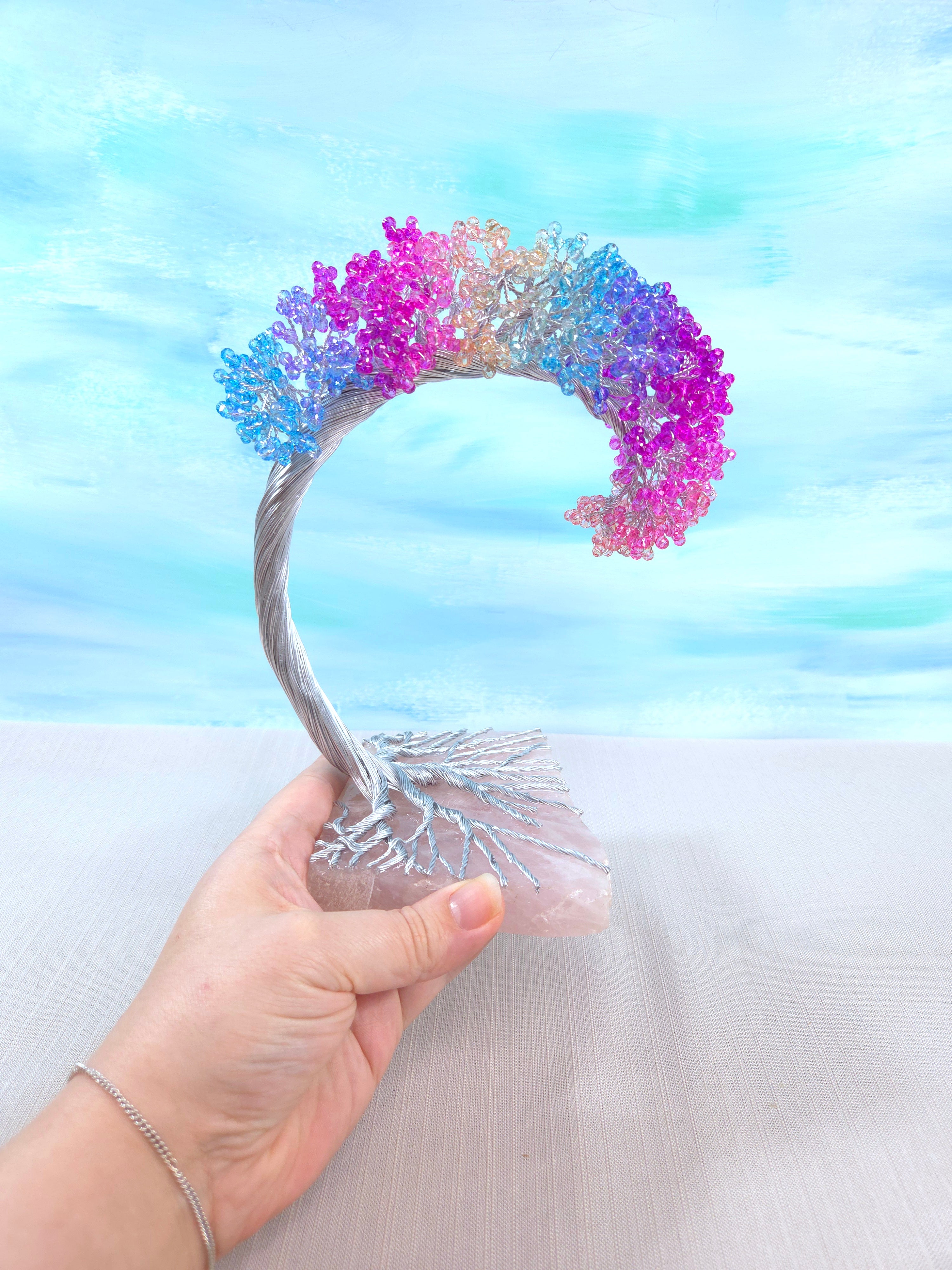 Colorful headband with a gradient design held by a hand against a light blue and white background.