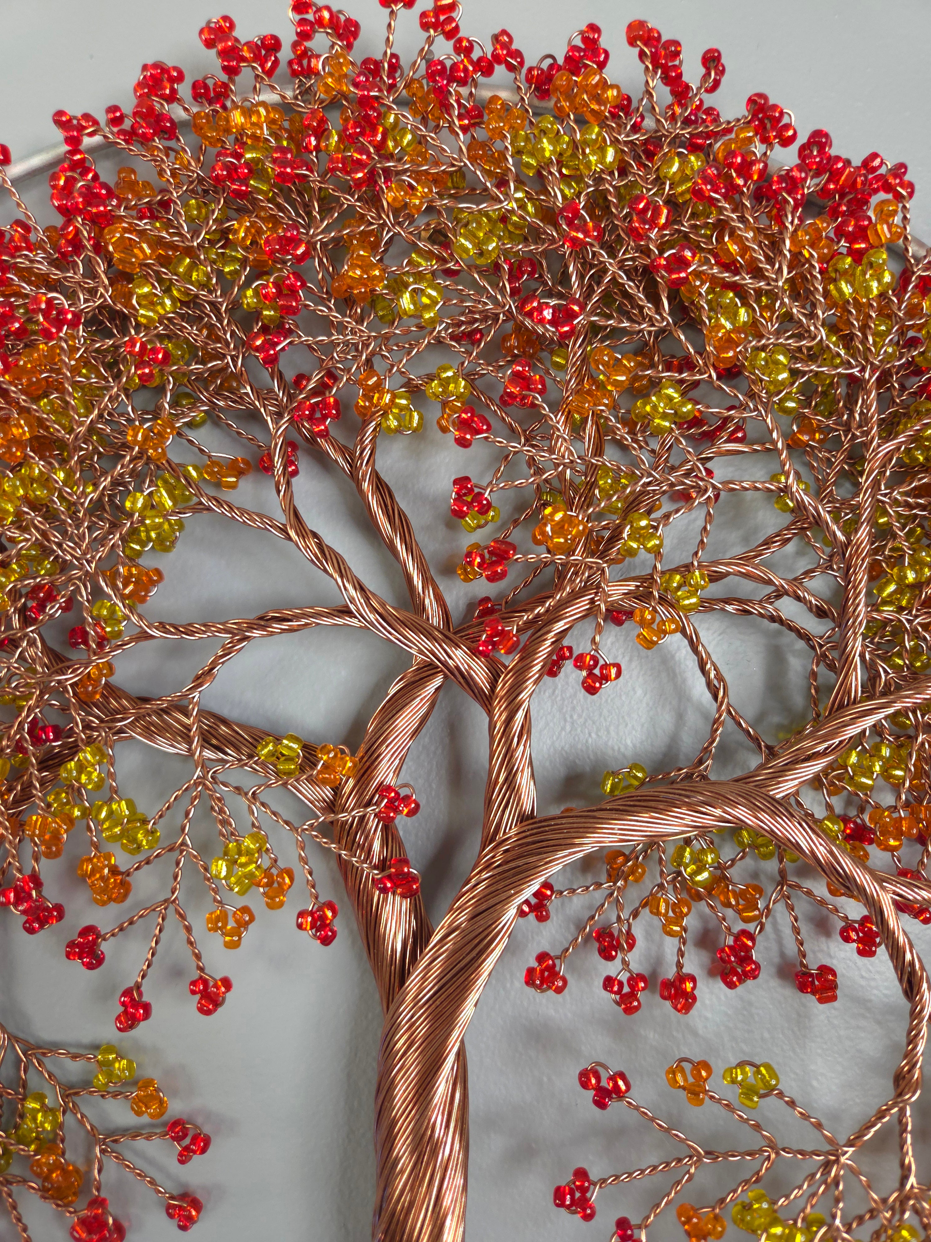 Decorative wall art of a tree with red and yellow berries on a gray background
