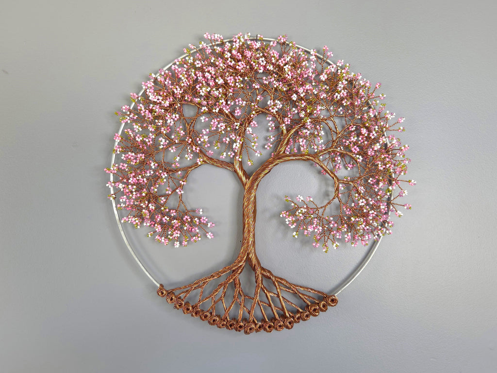 Decorative wall art of a tree with pink blossoms on a gray background