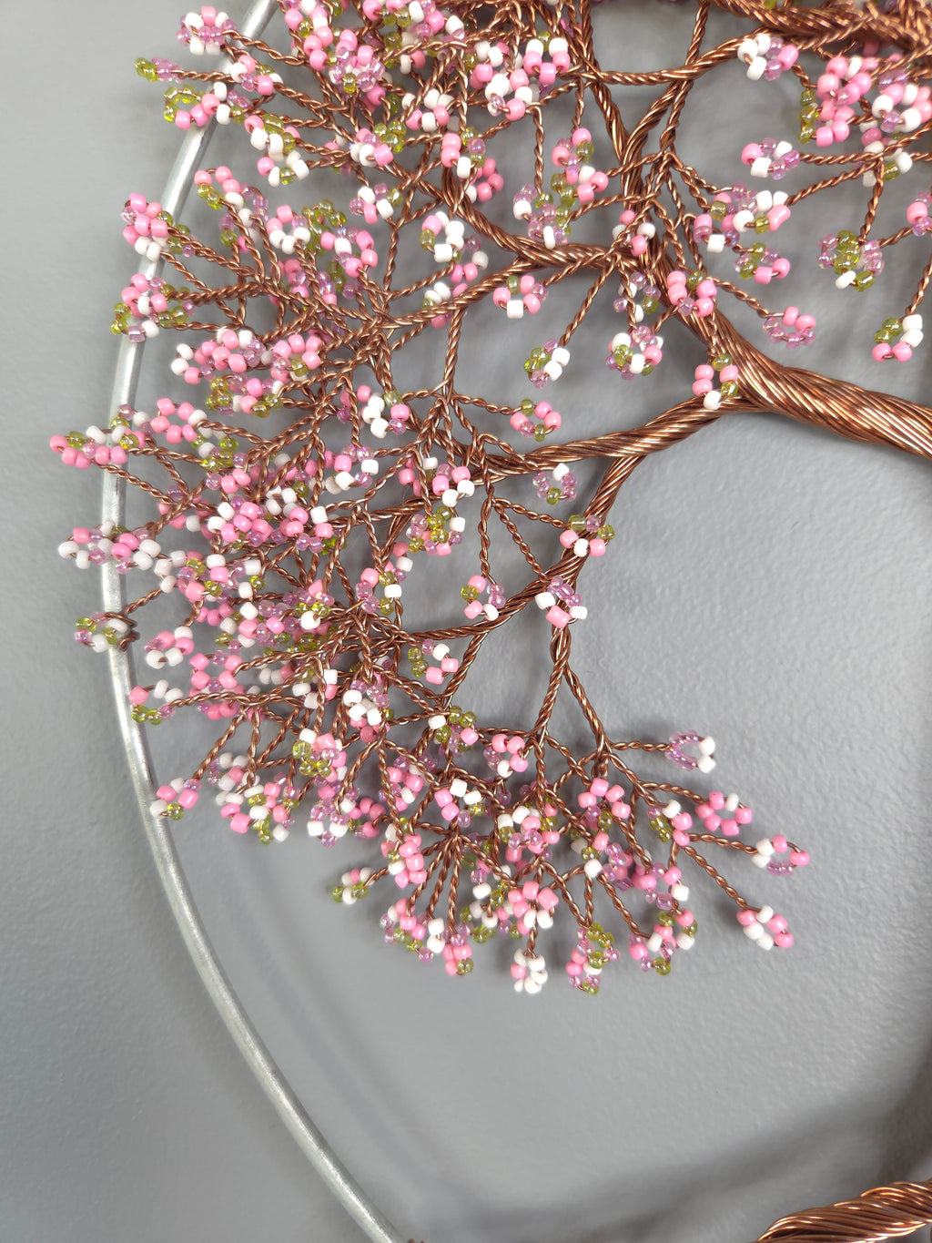 Decorative wreath with pink and white berries on a plain background