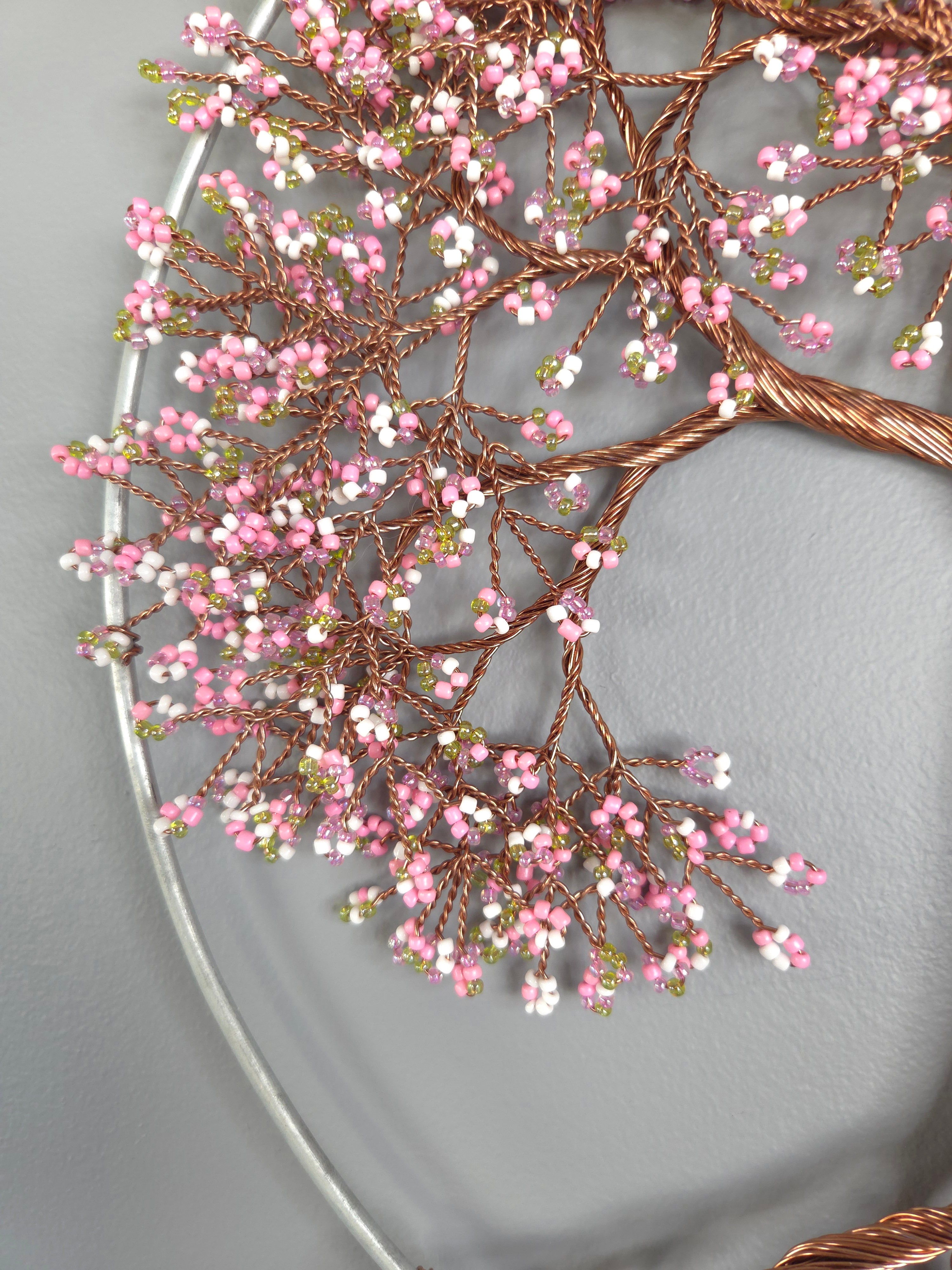 Decorative wreath with pink and white berries on a plain background