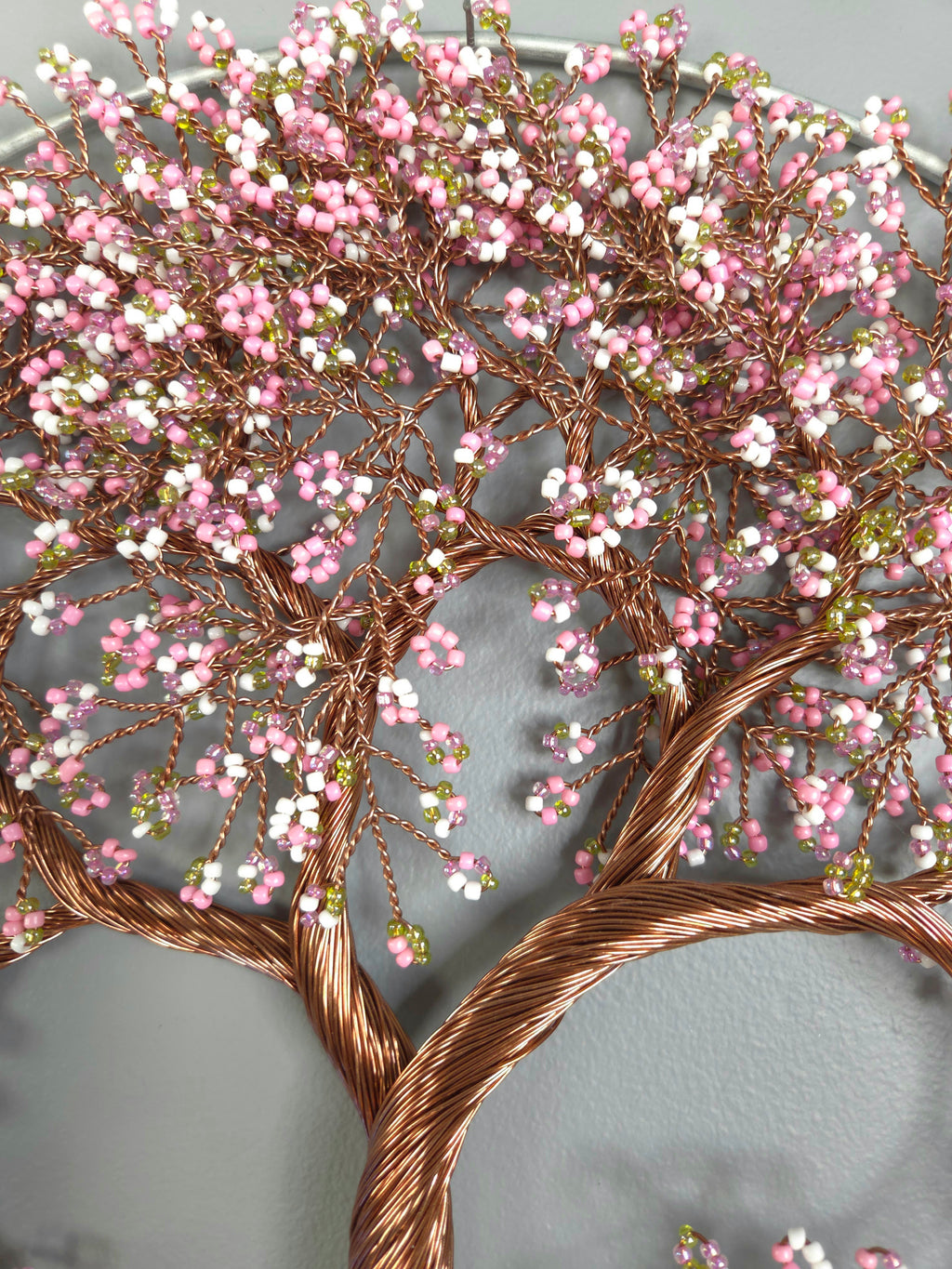 Decorative wall art of a tree with pink blossoms on a gray background