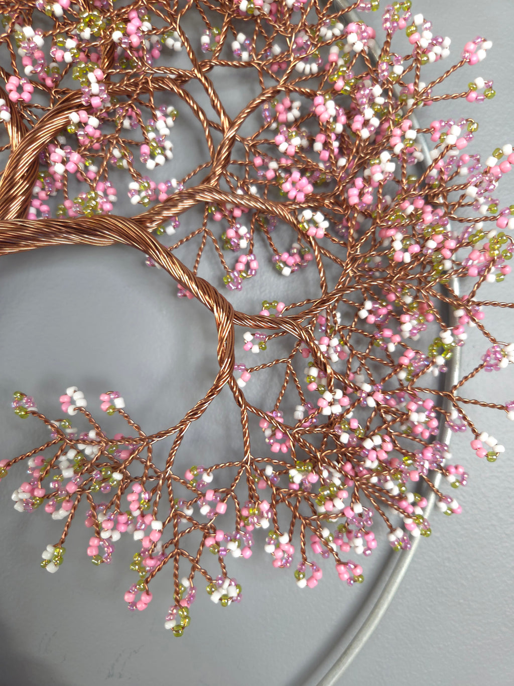 Decorative wreath with pink and white berries on a gray background