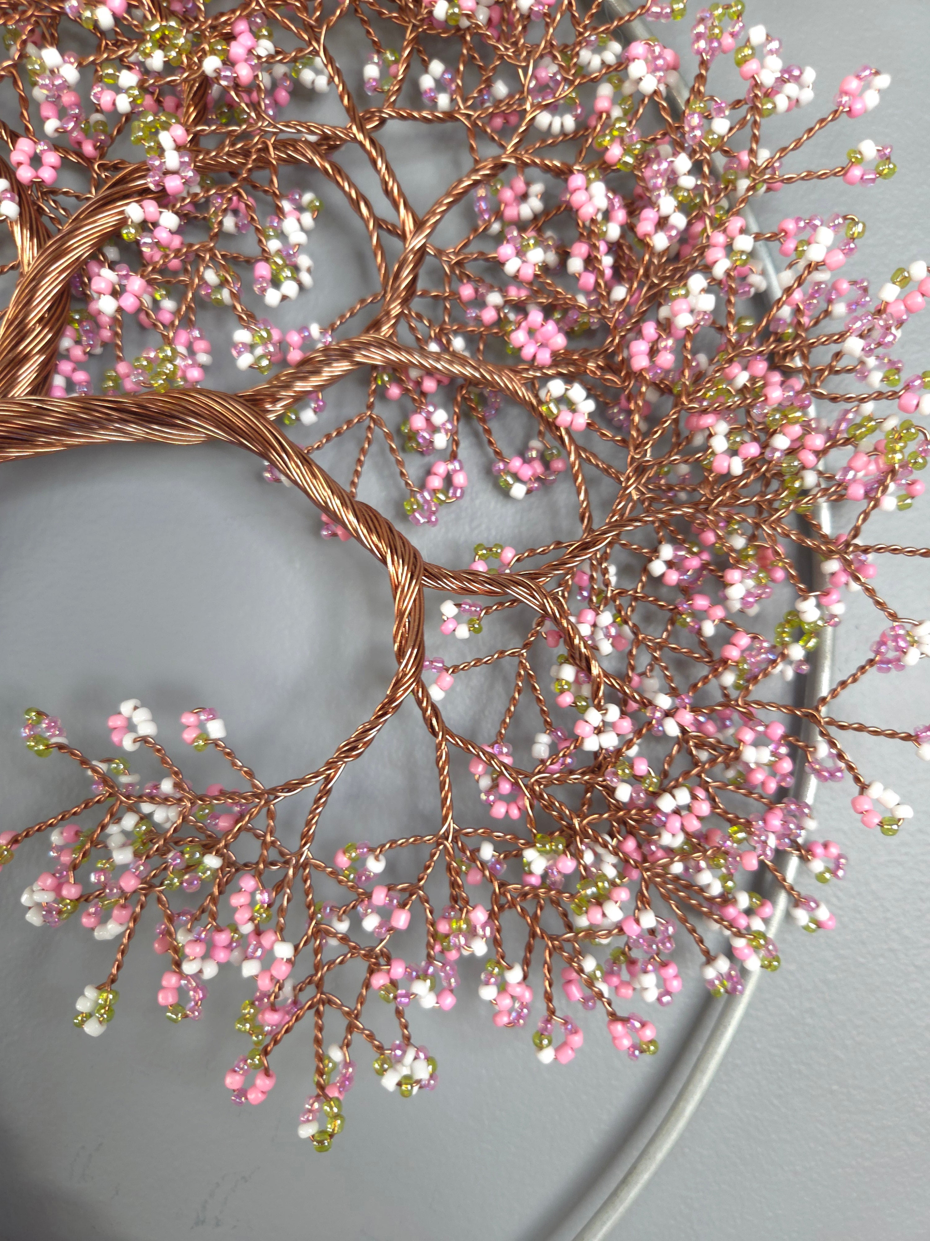 Decorative wreath with pink and white berries on a gray background