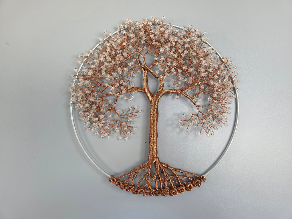 Decorative wall art of a tree with a circular metal frame on a plain background