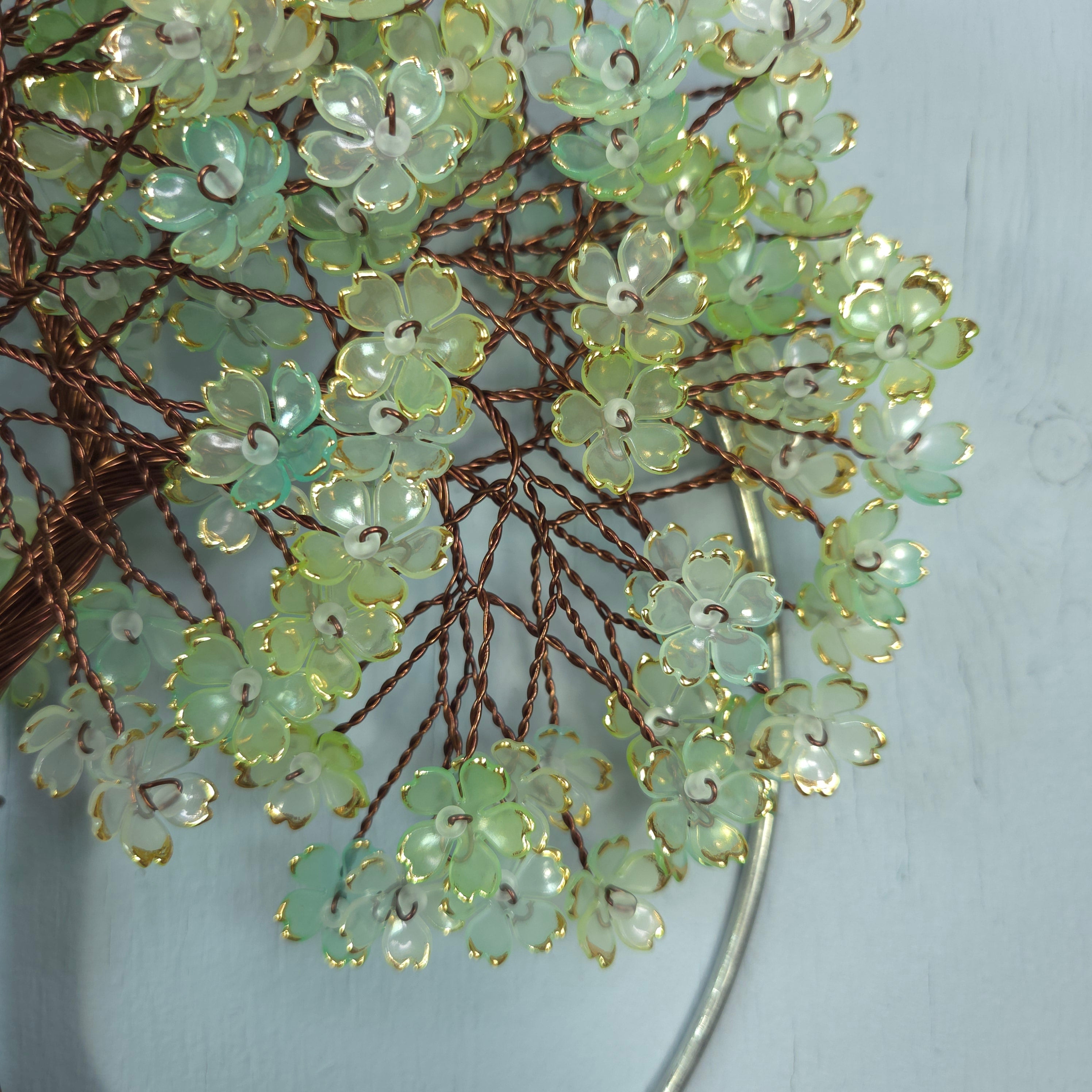 Decorative brooch with green floral design on a light gray background