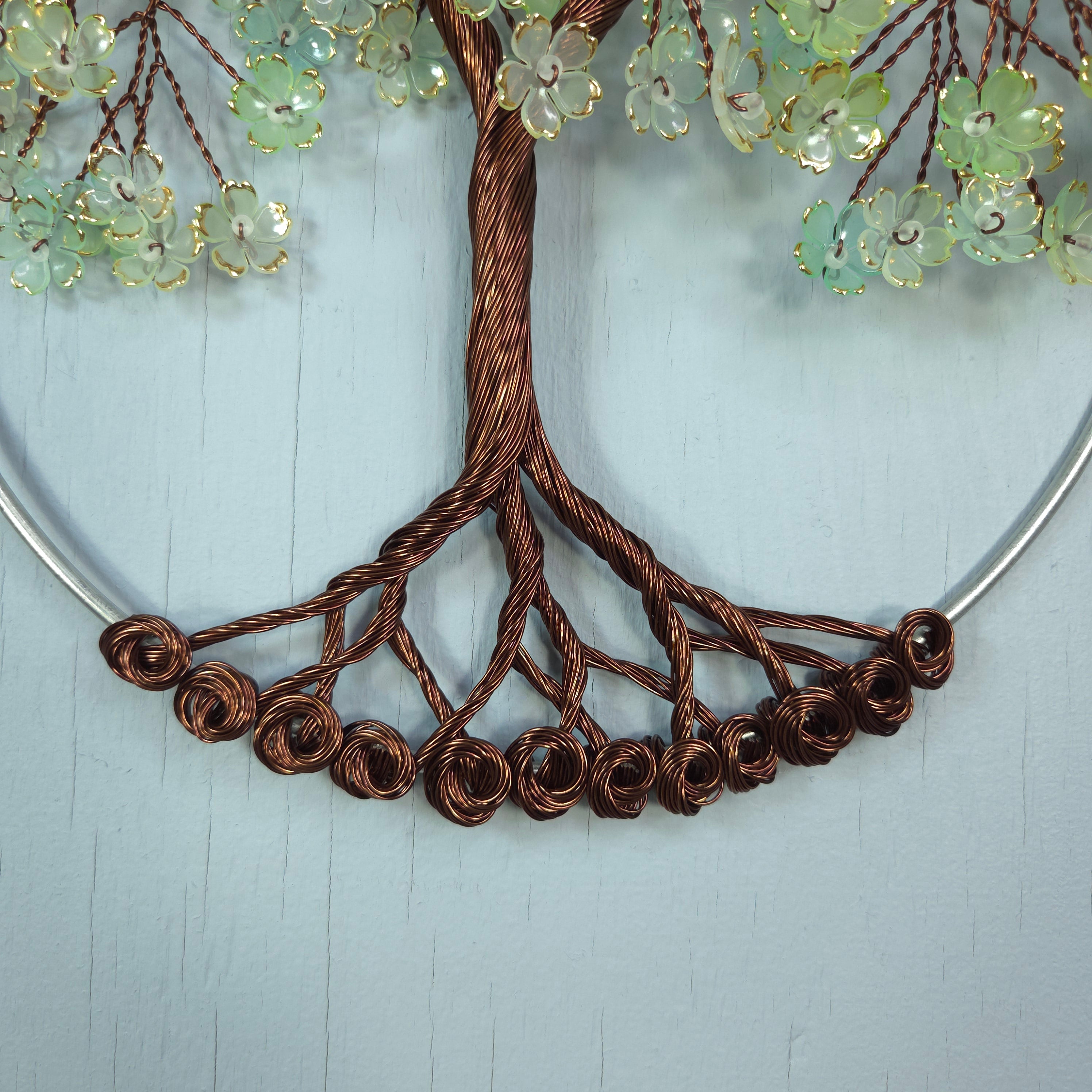 Decorative wreath with brown wire branches and green floral elements on a light blue background