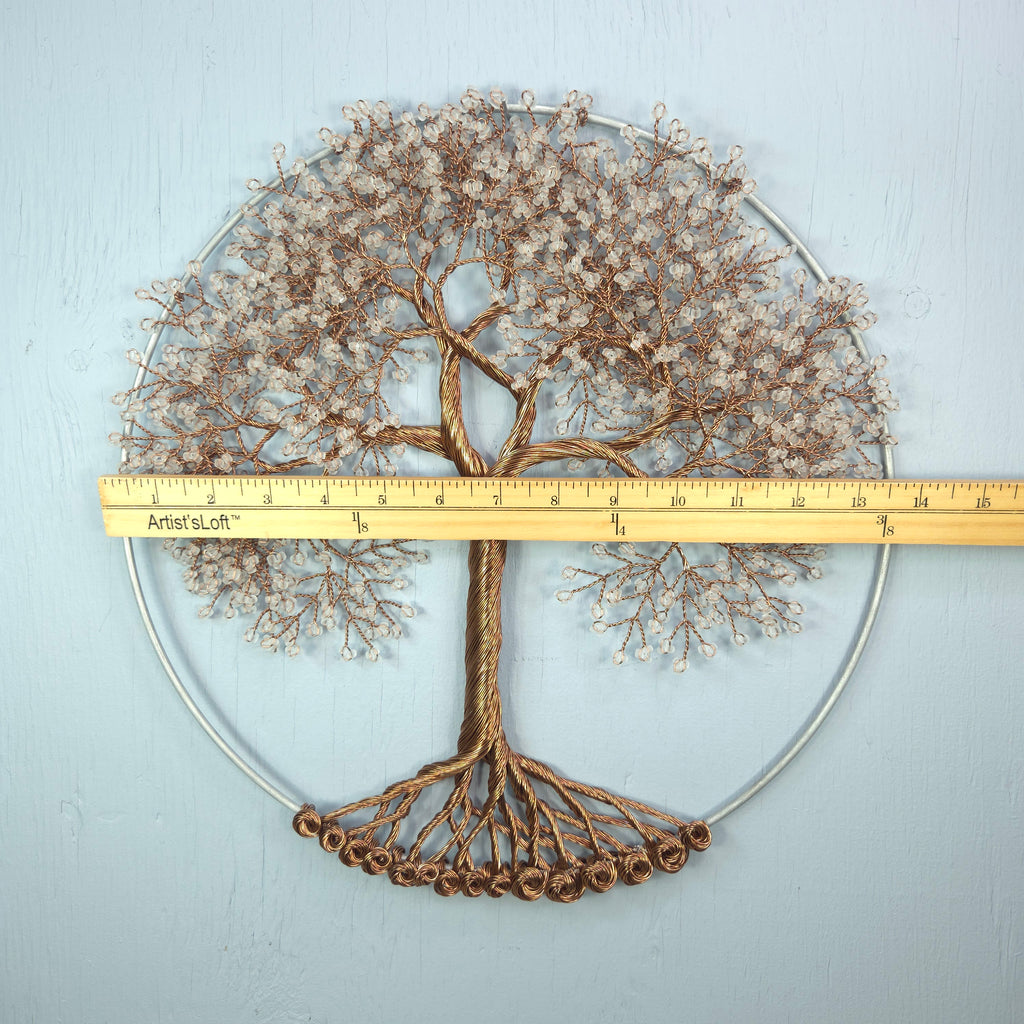 Decorative metal tree wall art with a ruler for scale on a light gray background
