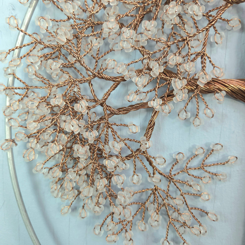 Decorative branch with small beads on a light blue background