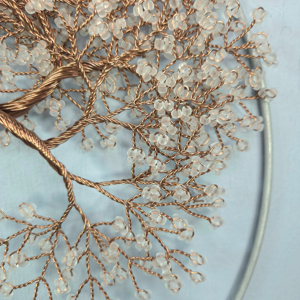 Decorative branch with small beads on a light blue background