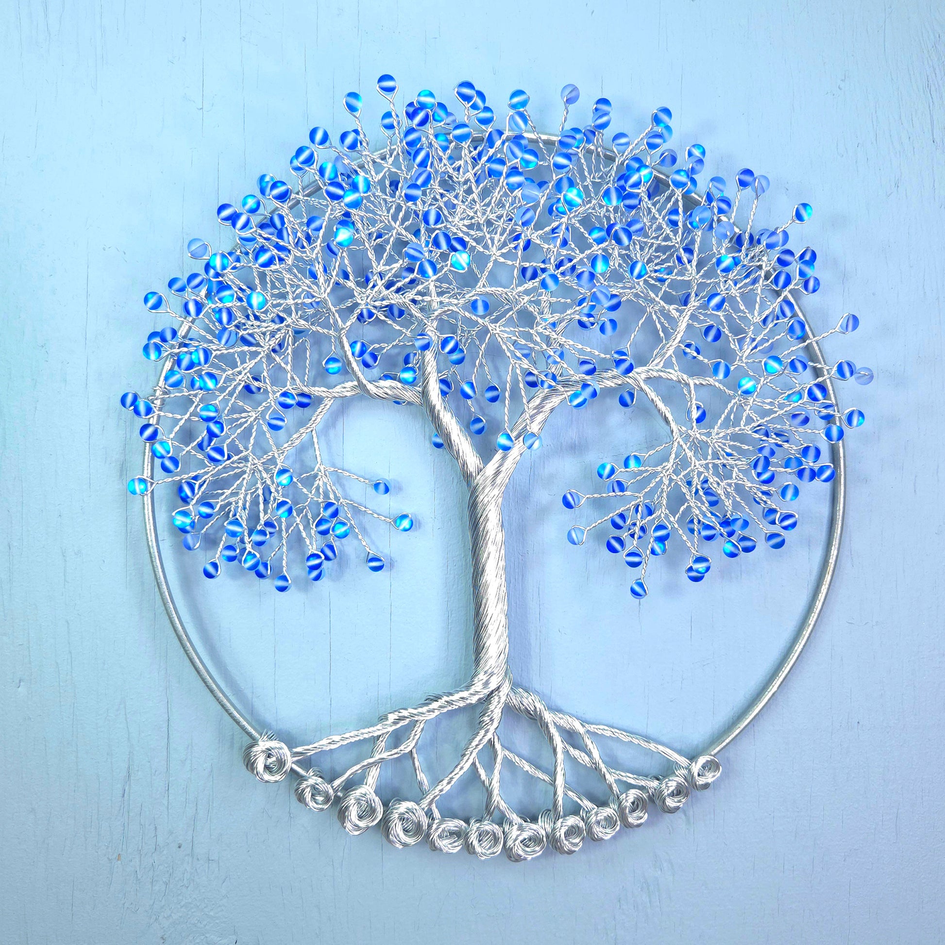 silver wire tree with blue beads and blue background