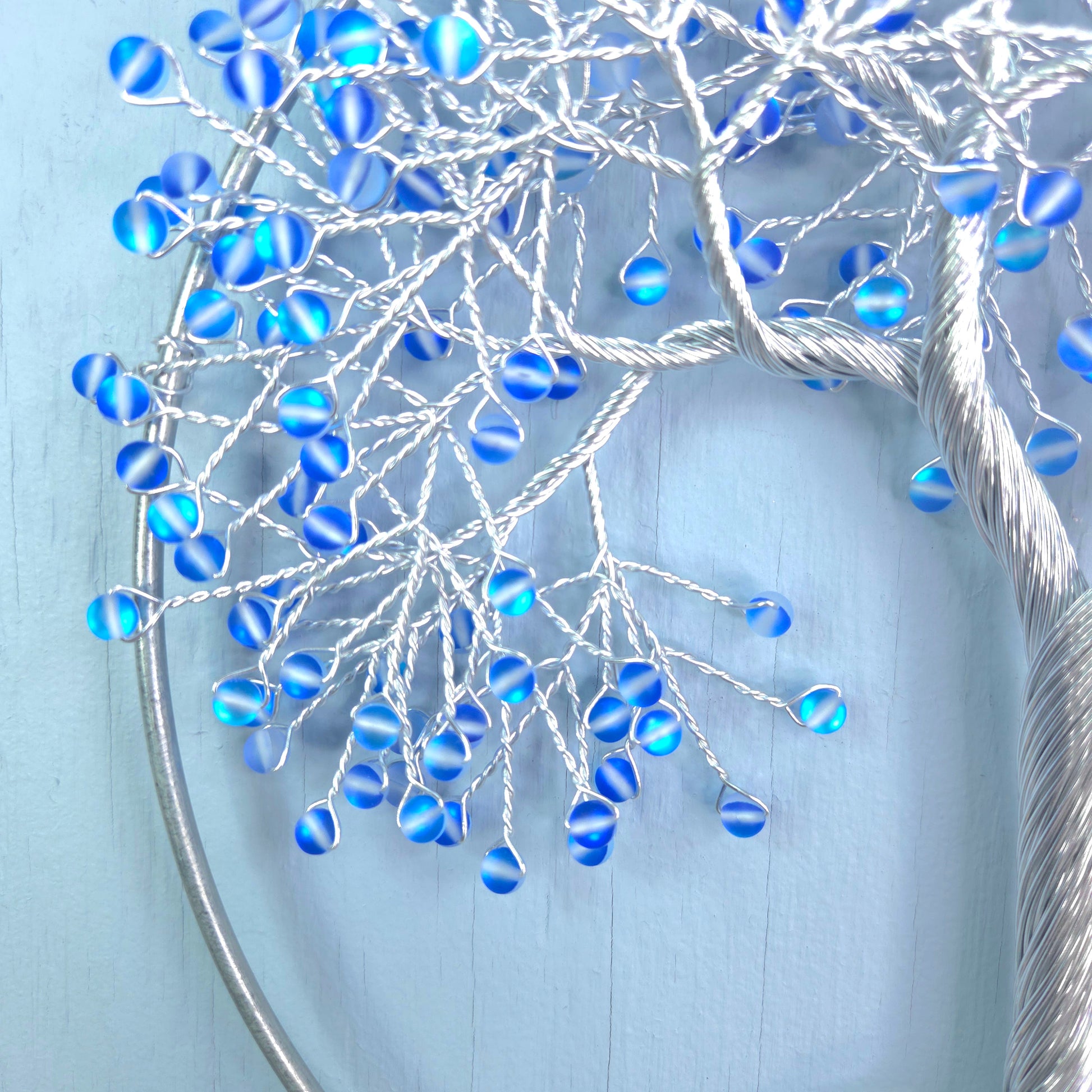 silver wire tree with blue beads and blue background
