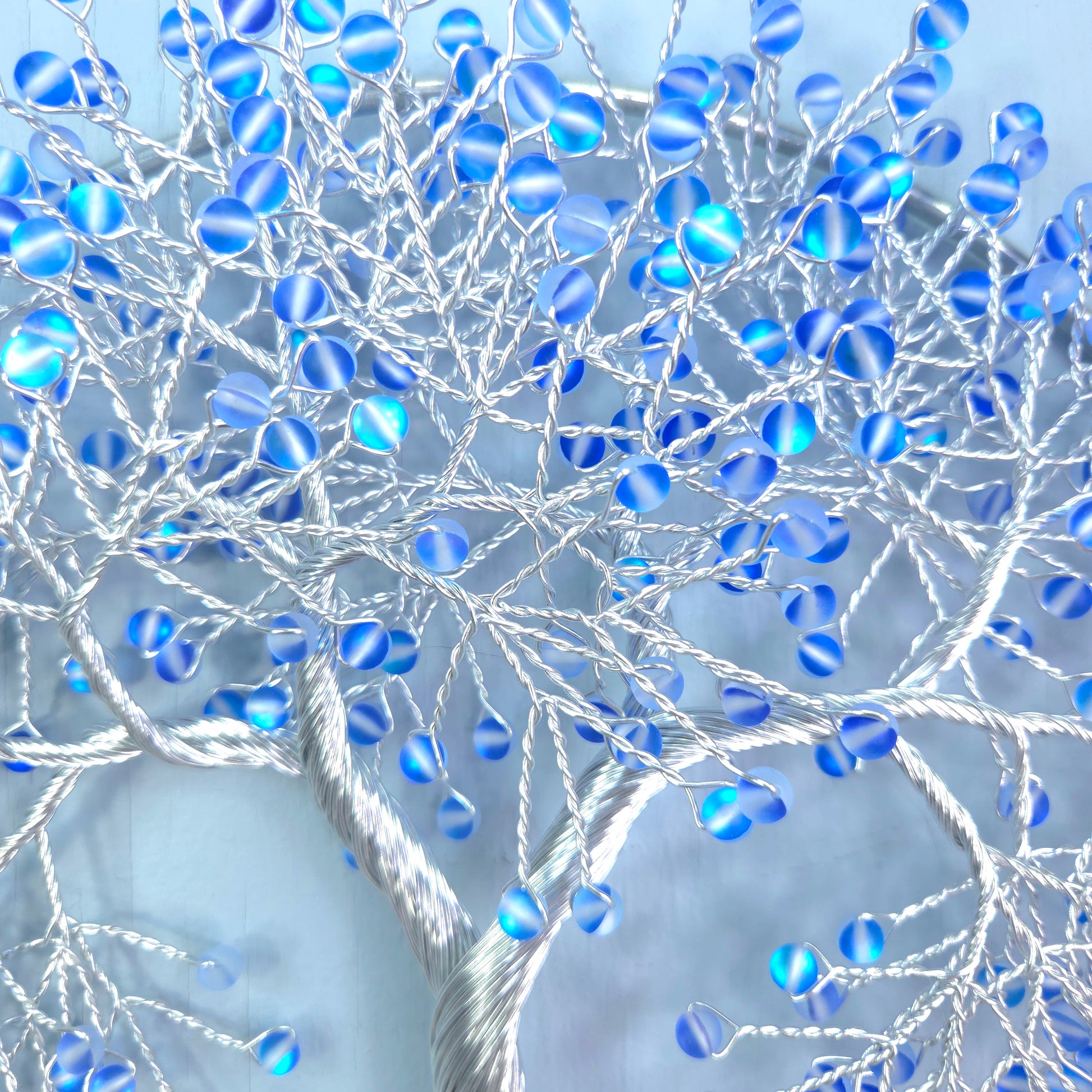 silver wire tree with blue beads and blue background