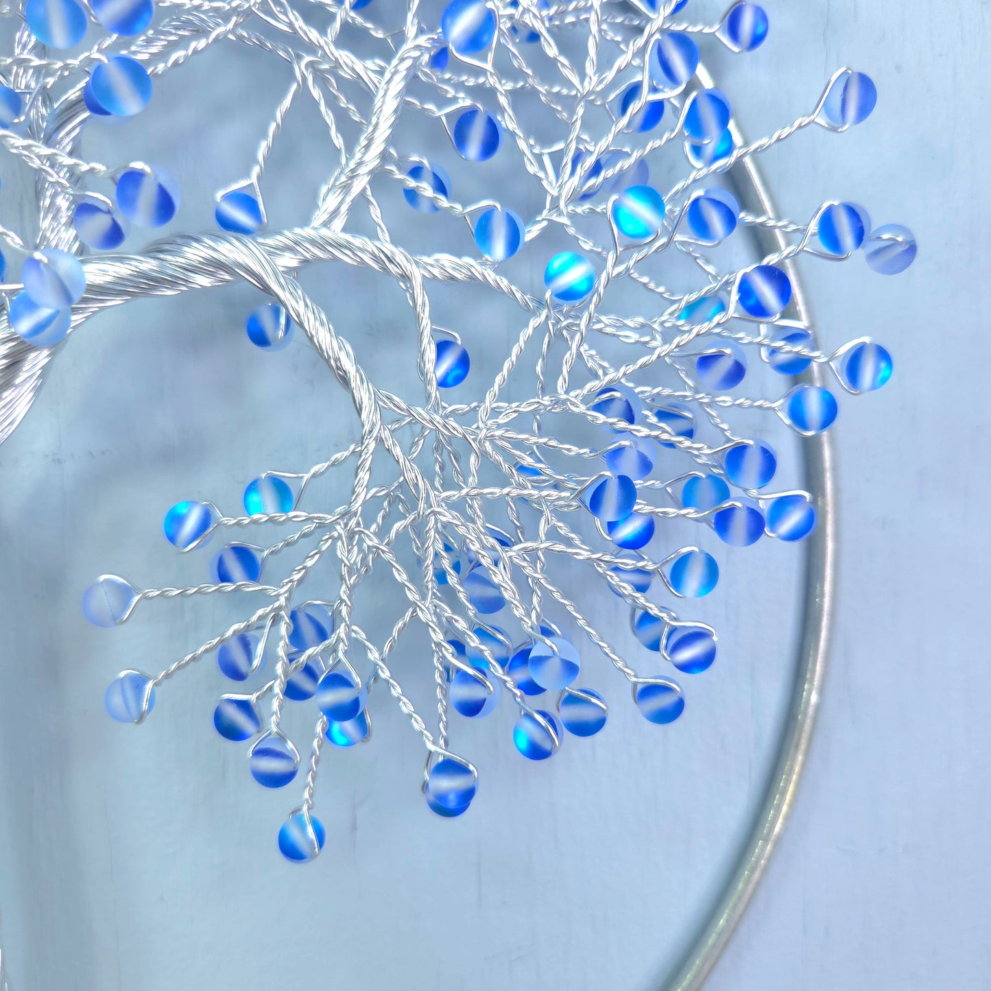 silver wire tree with blue beads and blue background