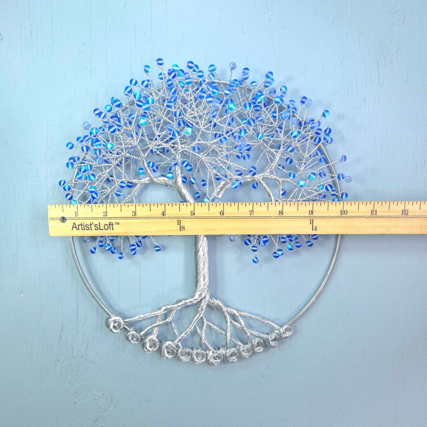 silver wire tree with blue beads and blue background