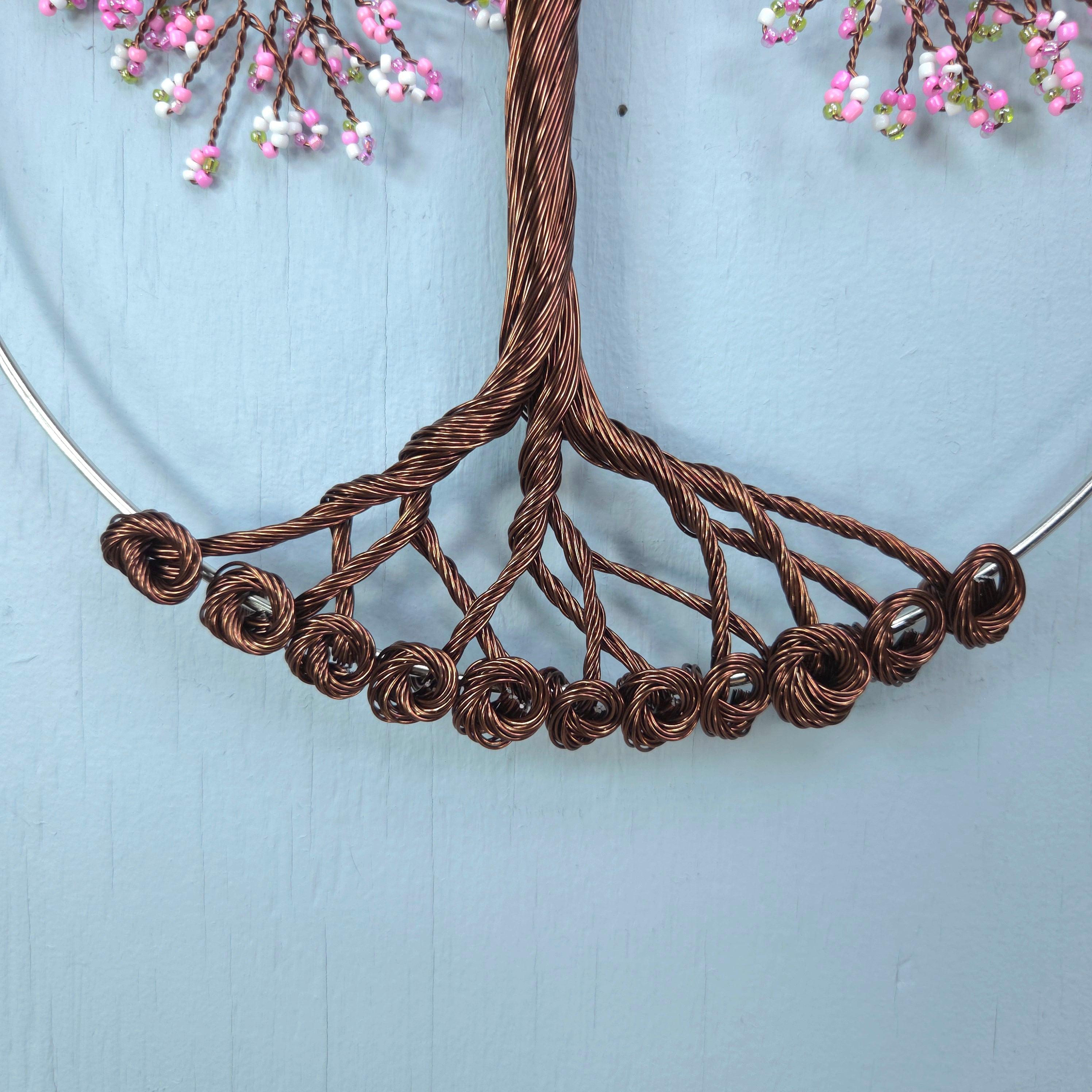 Brown wire necklace with floral elements on a light blue background
