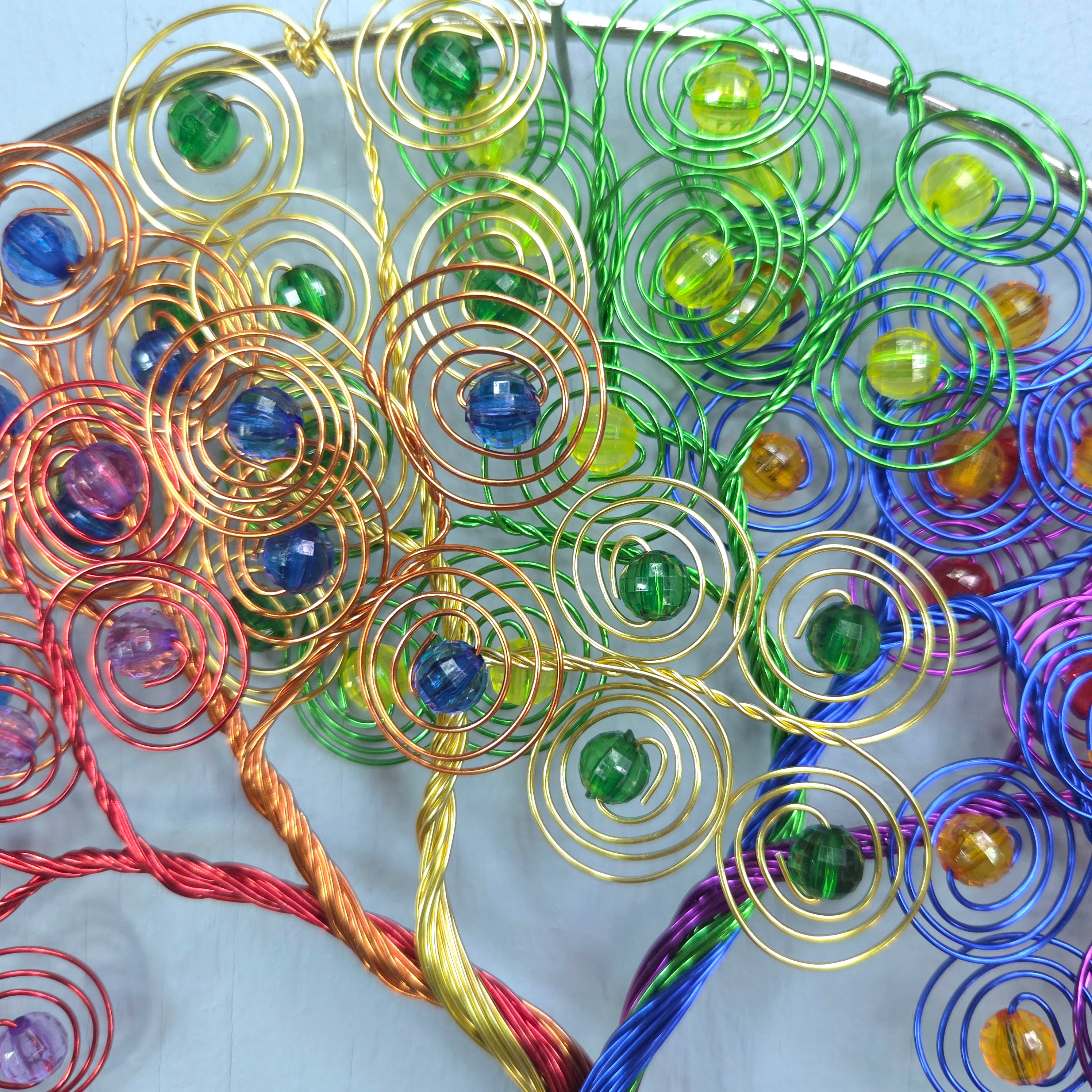 Colorful wire tree sculpture with beads on a white background