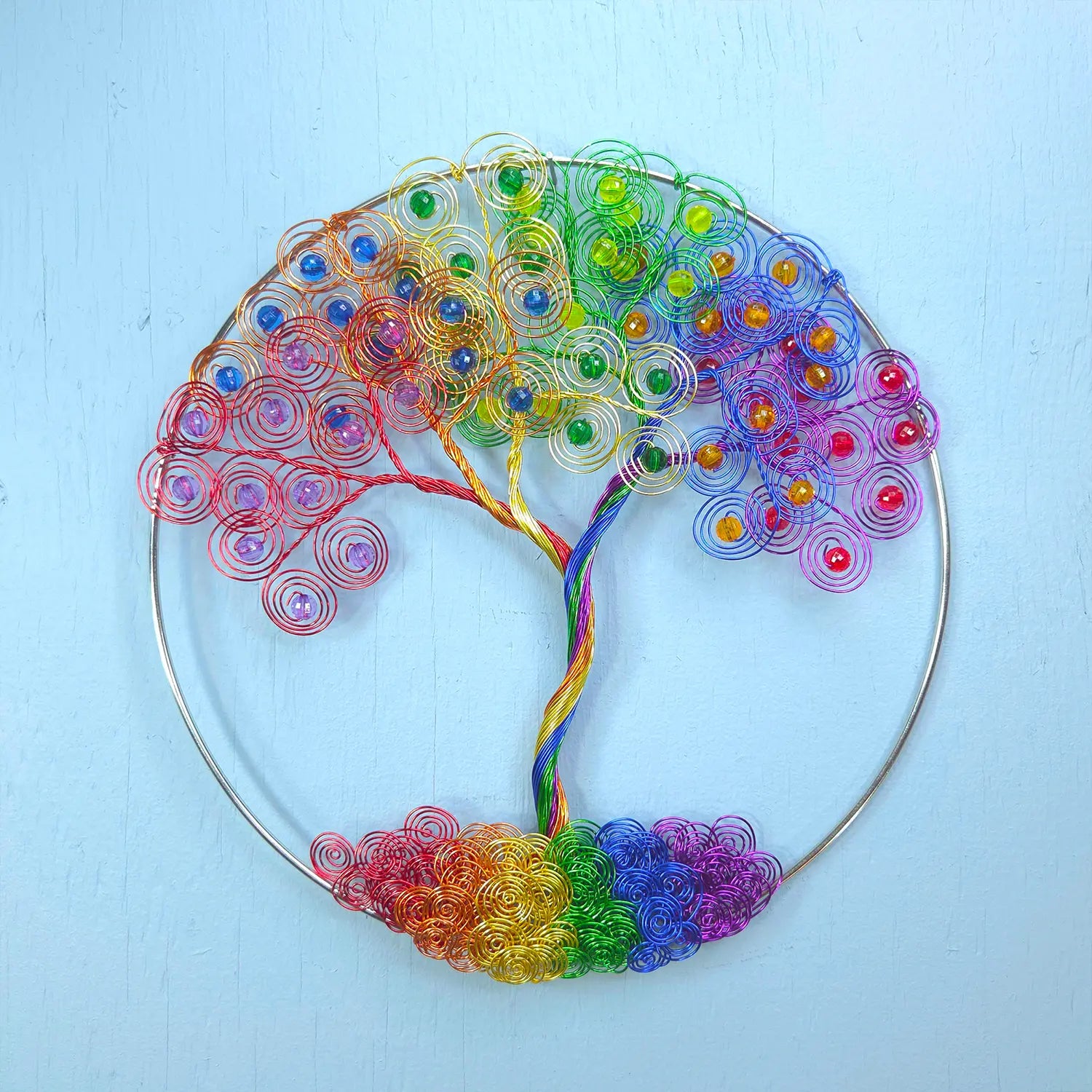 Colorful wire tree sculpture on a light blue background