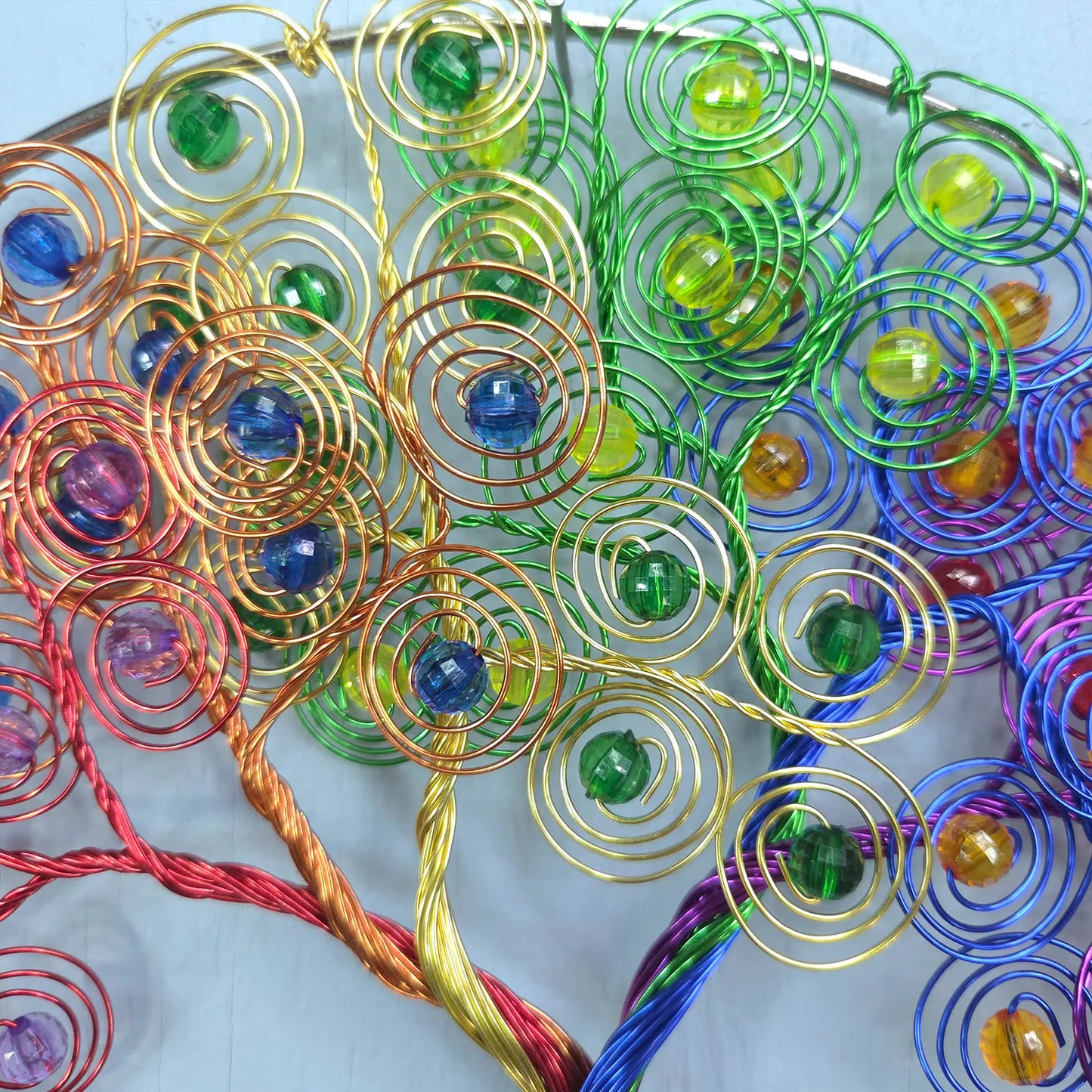 Colorful wire tree sculpture with beads on a white background