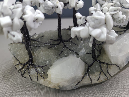 Decorative stone arch with white stones and black wire, on a gray surface.