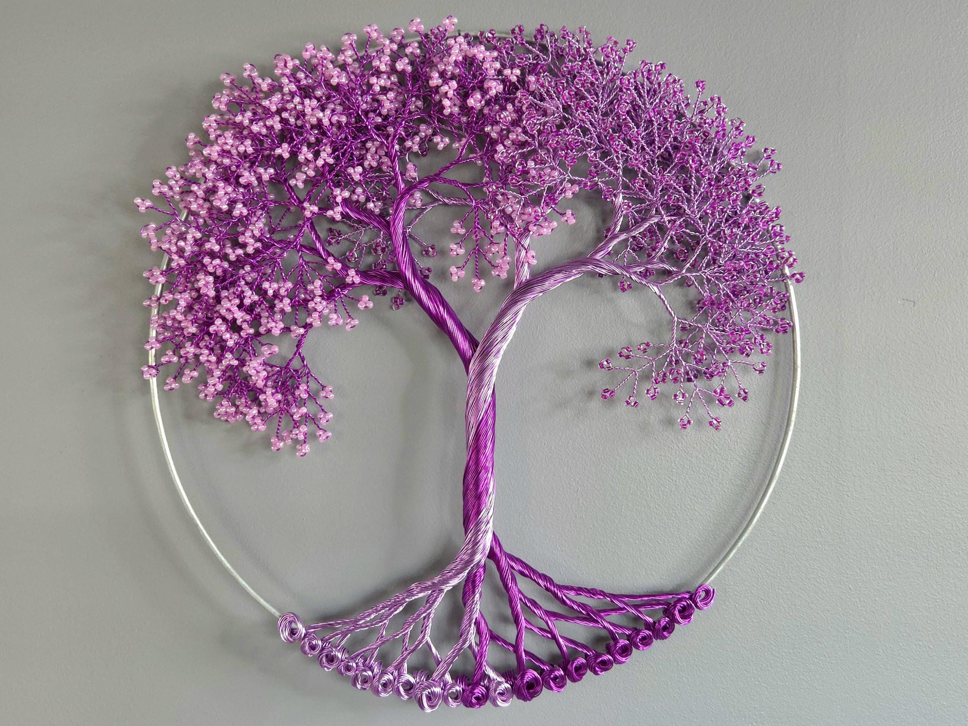 Decorative wall art of a purple tree with a heart-shaped base on a gray background