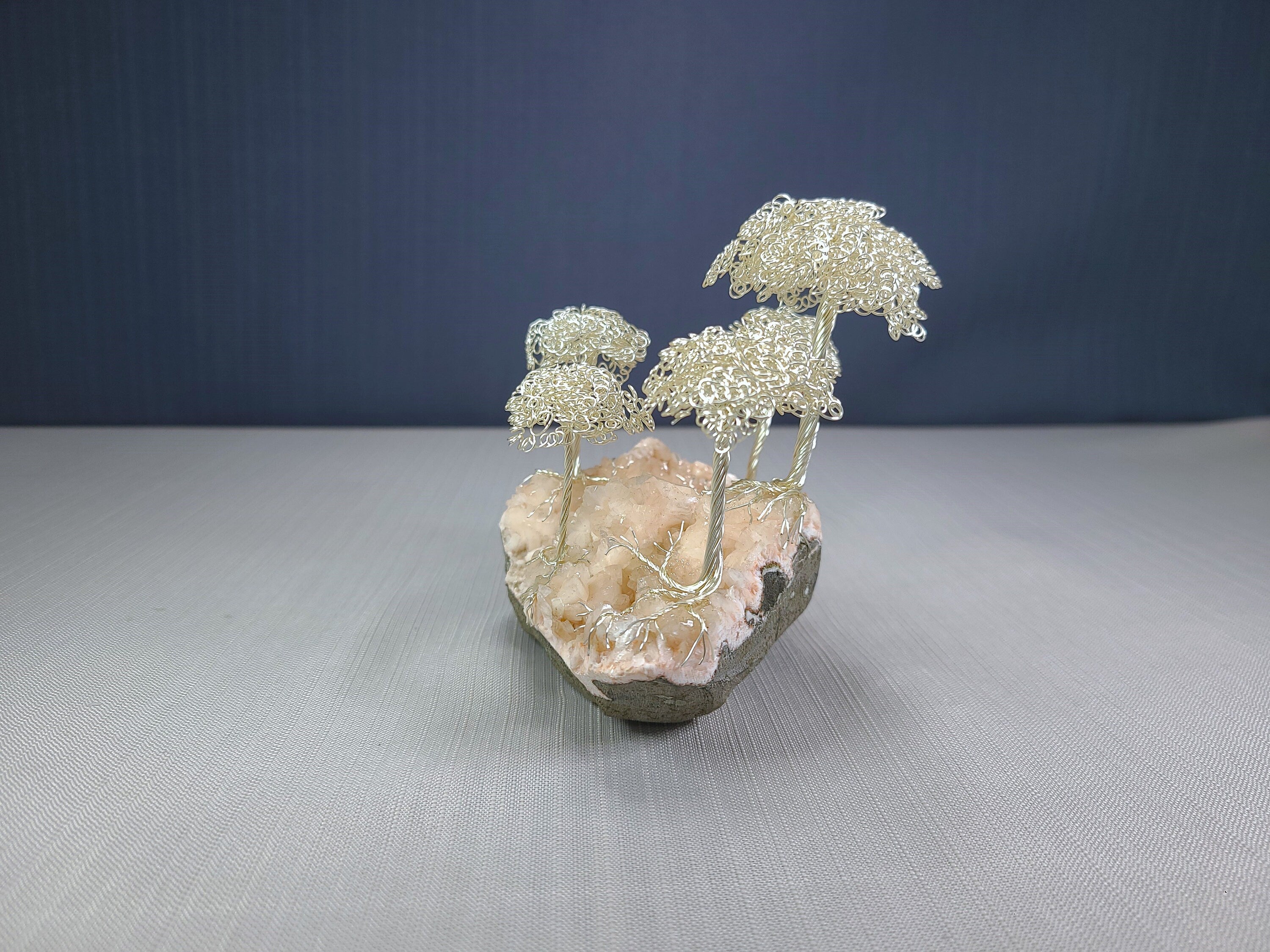 Decorative sculpture of trees on a rock with a dark blue background