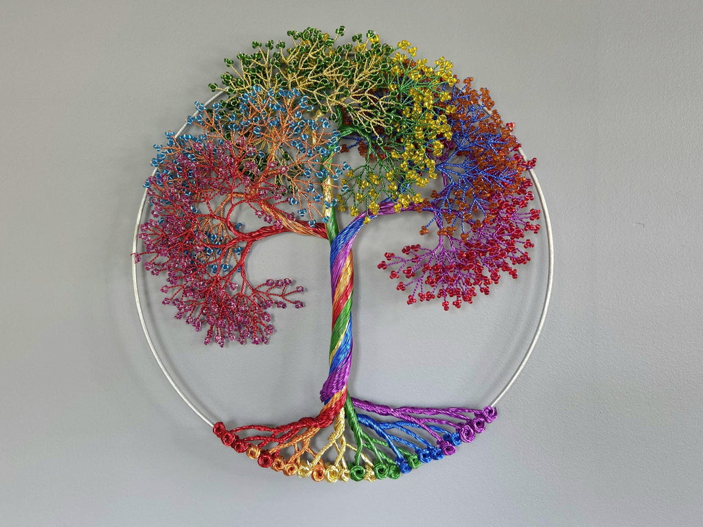 Colorful tree sculpture with a rainbow trunk on a plain background