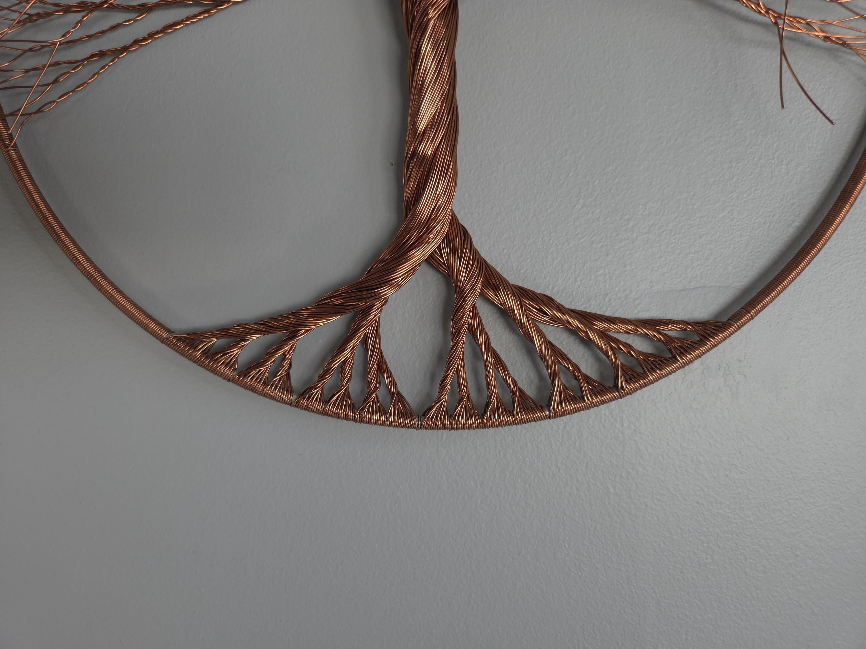Decorative wall art with braided brown wire on a gray background