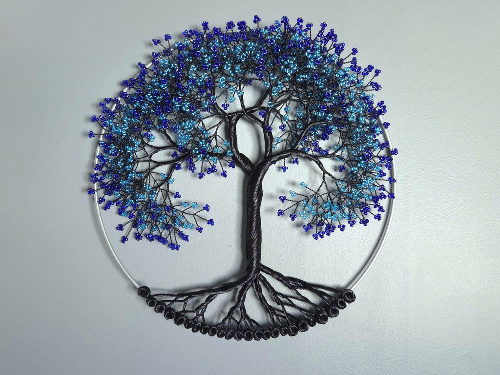 Decorative wall art of a tree with blue and black branches on a light gray background