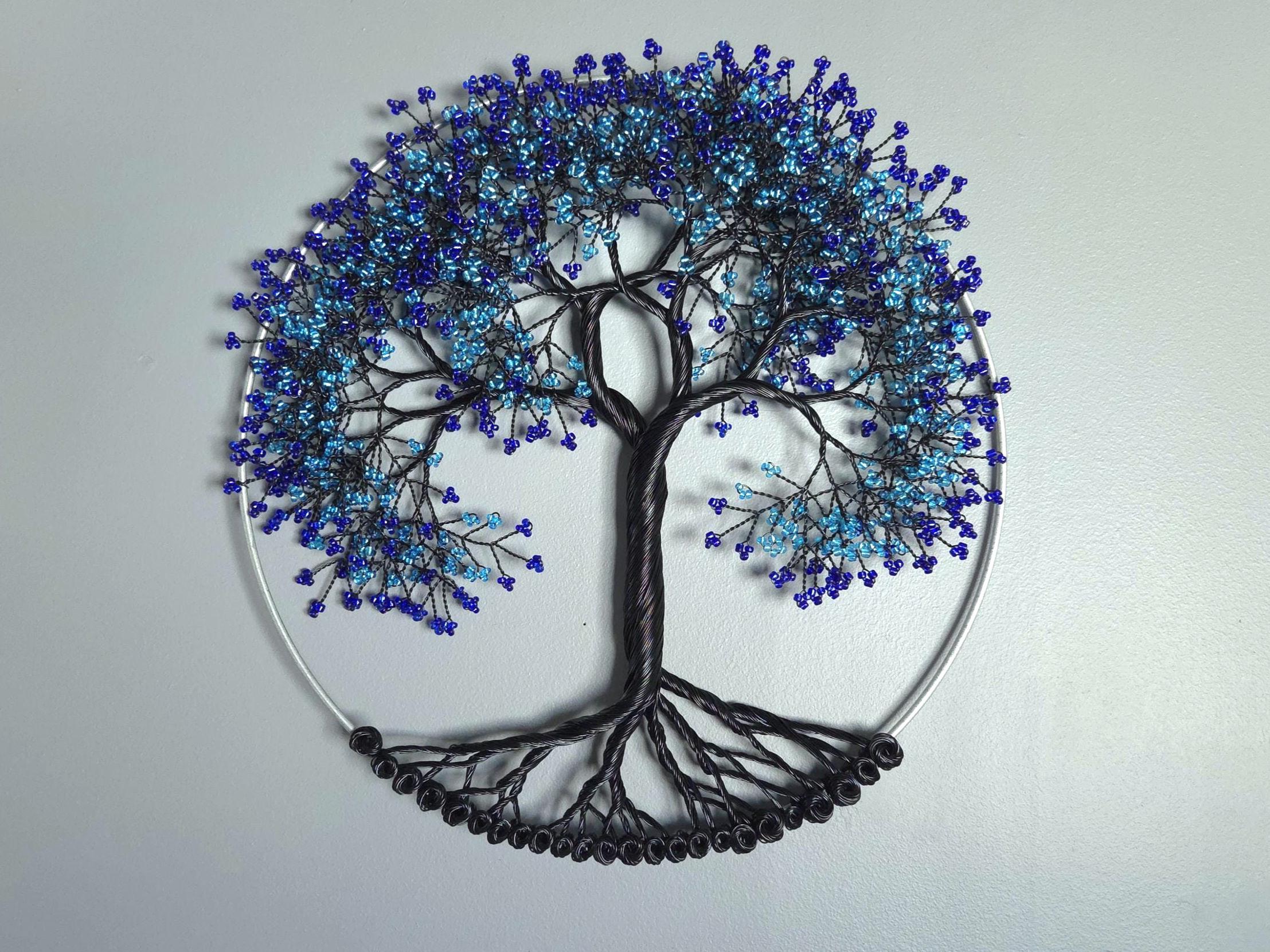 Decorative wall art of a tree with blue and black branches on a light gray background