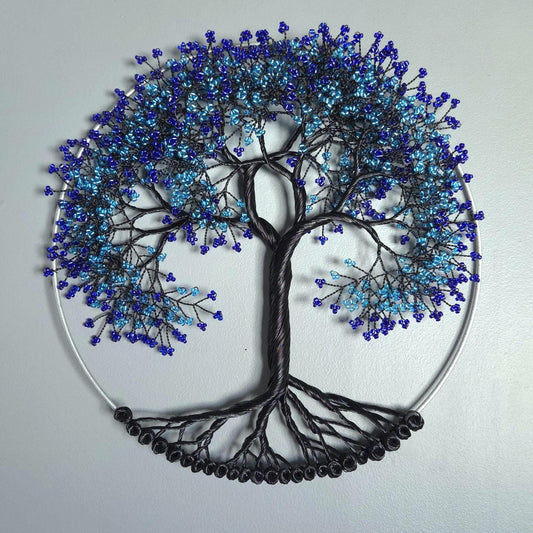 Decorative wall art of a tree with blue and black branches on a light gray background